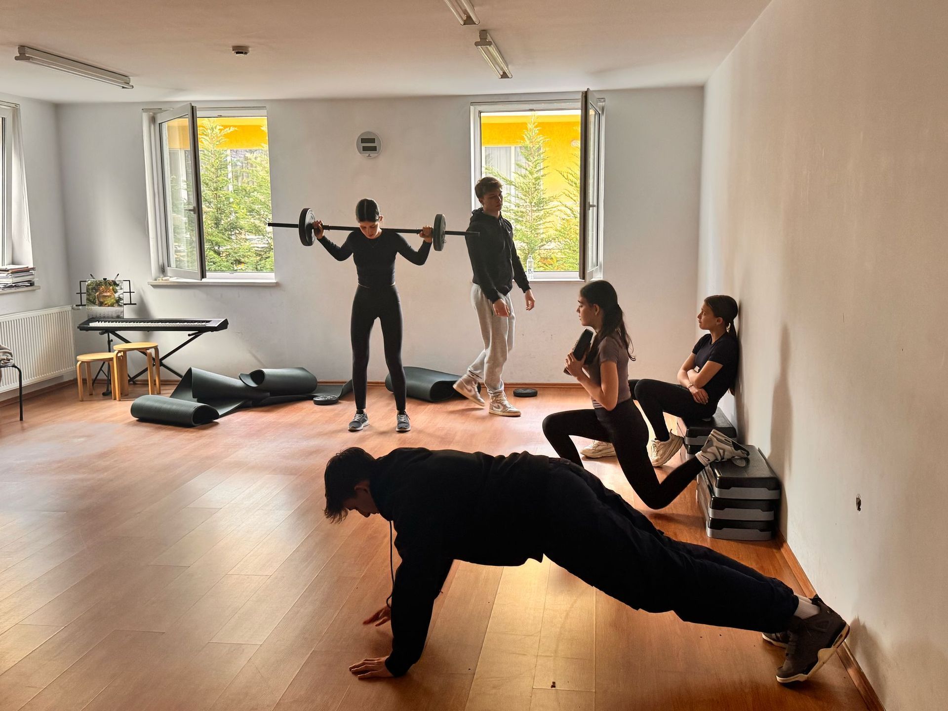 A group of people are doing push ups in a gym.