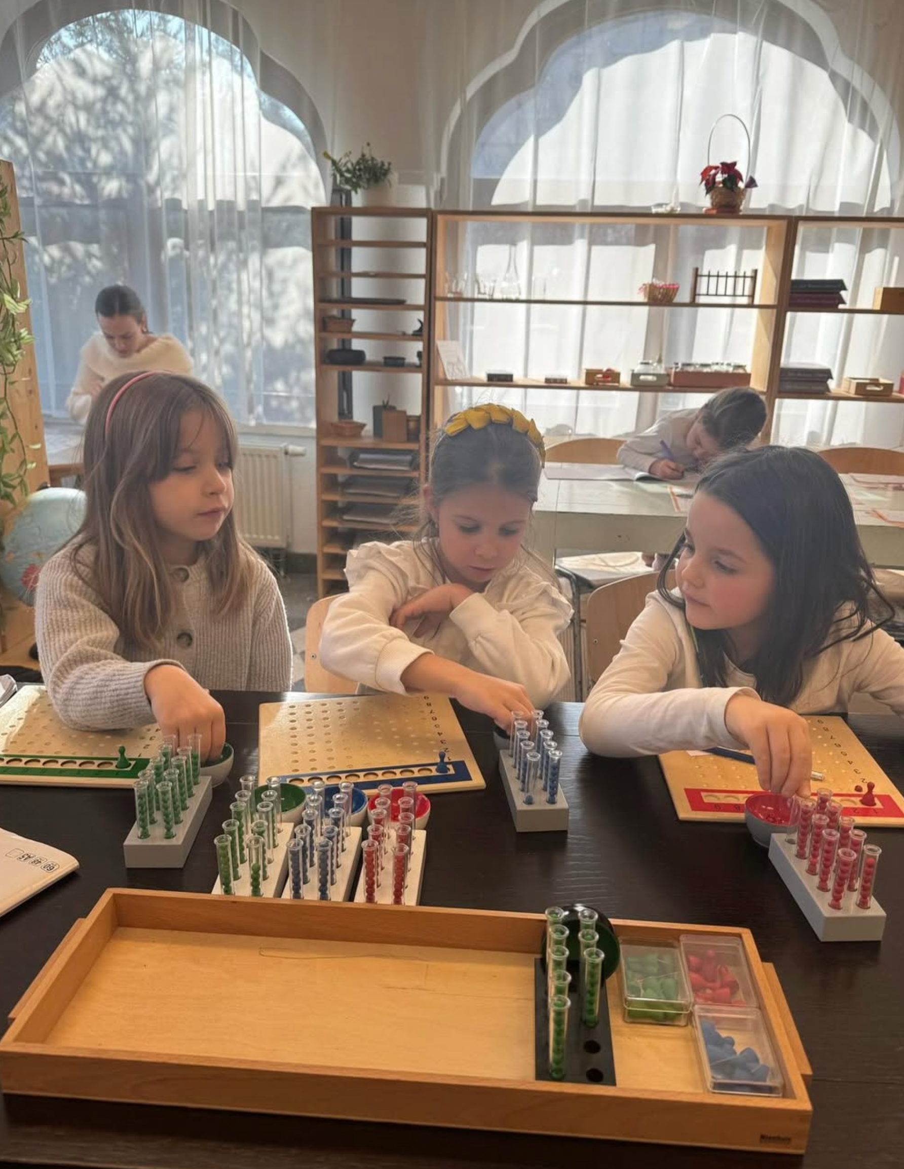 A group of young girls are sitting at a table playing a game.