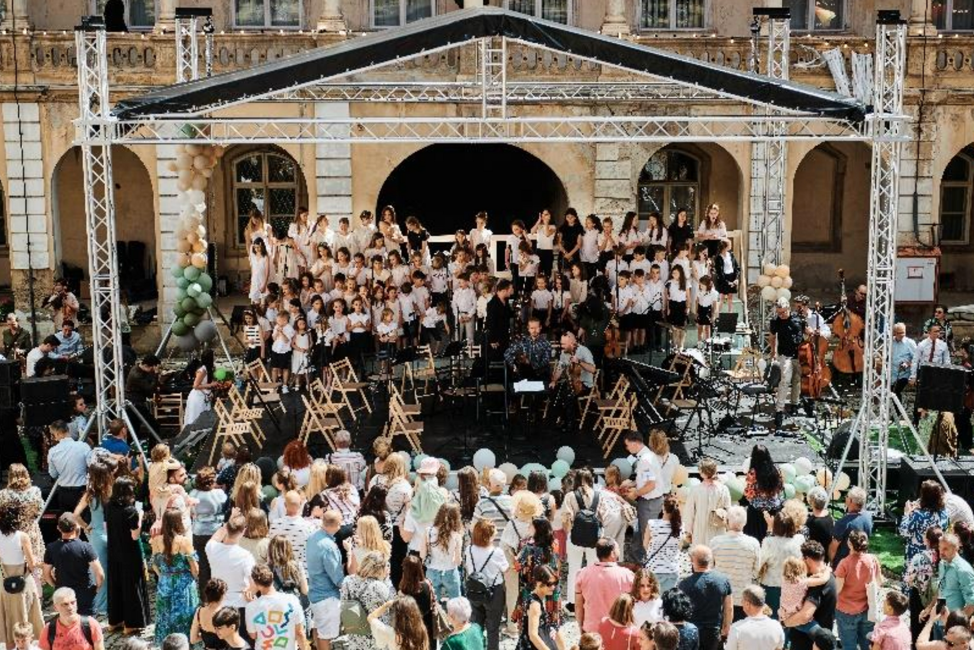 A large group of people are standing in front of a stage.