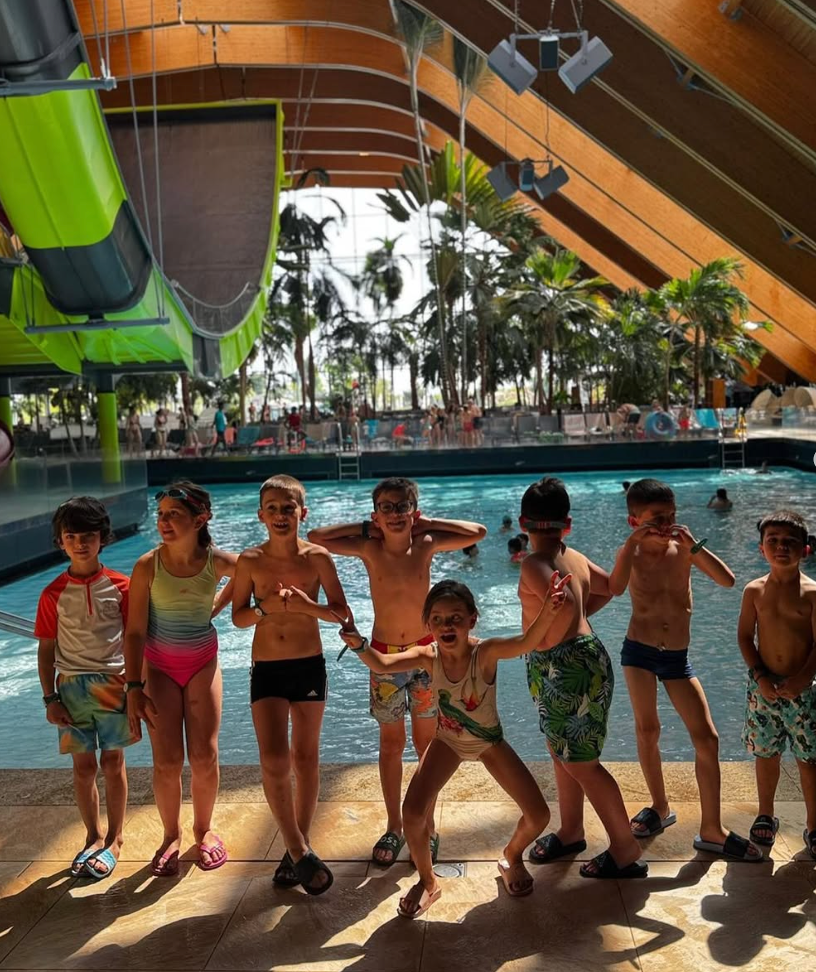 A group of children are posing for a picture in front of a swimming pool.