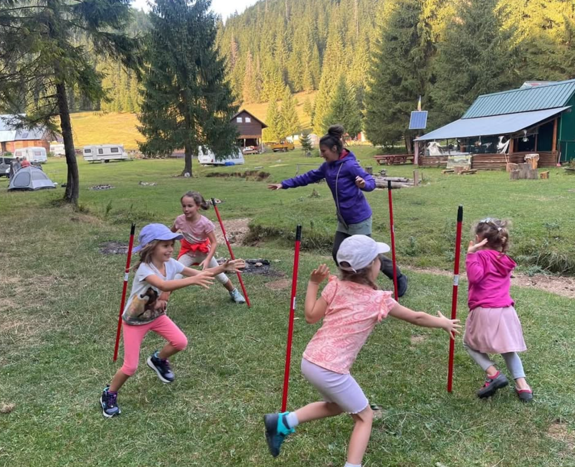 A group of children are playing with walking poles in a field.