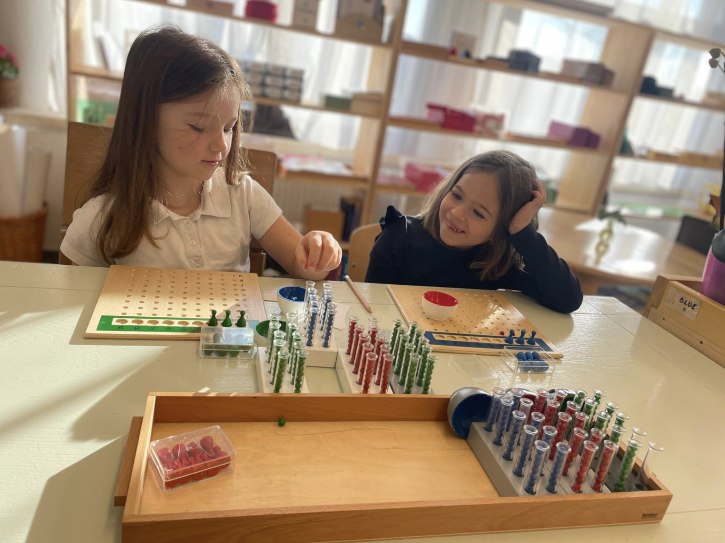 Fetita de gradinita lucrand cu materialele de Matematica la Gradinita Montessori Cluj.