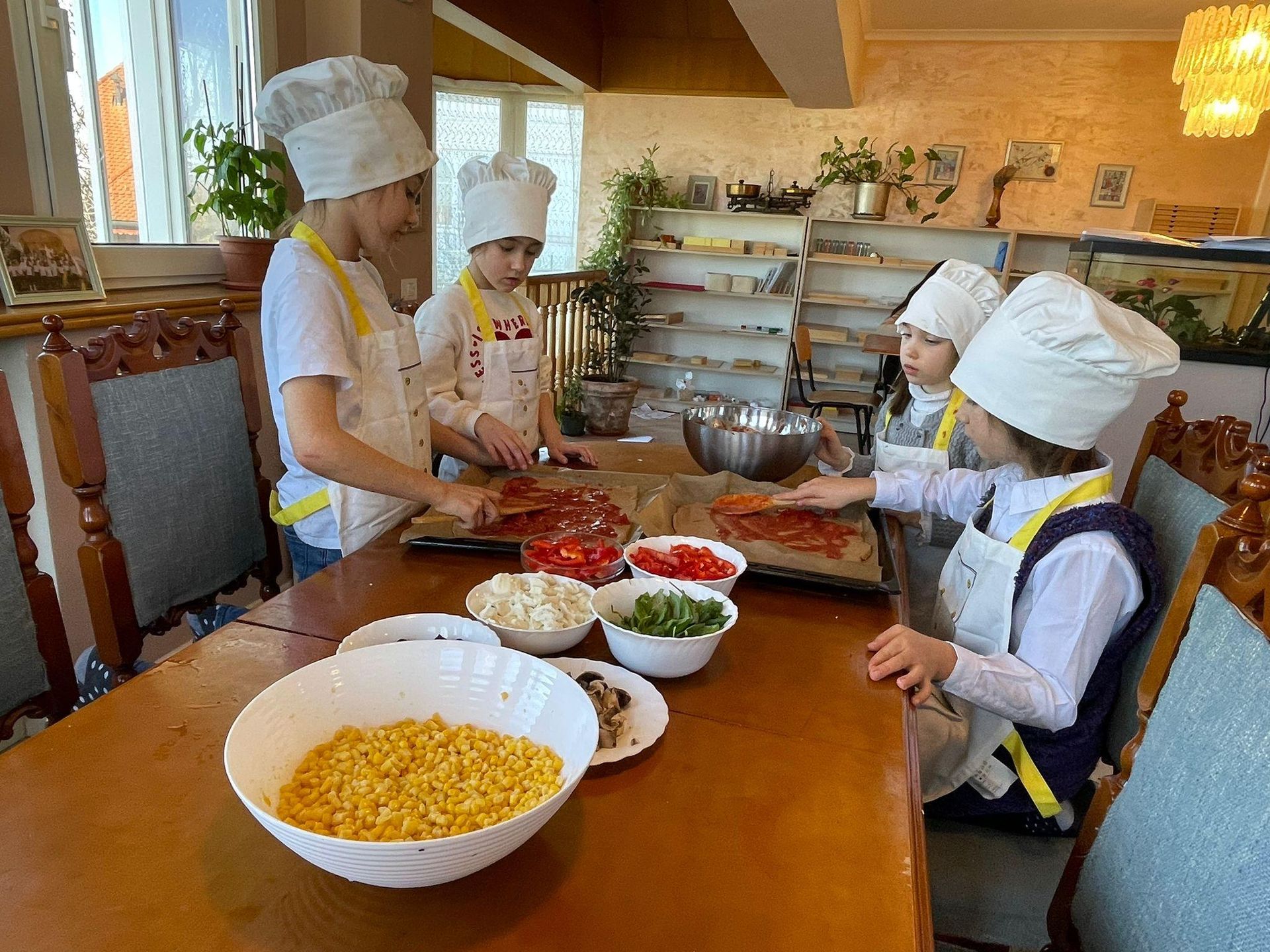 A group of children are sitting at a table preparing food.