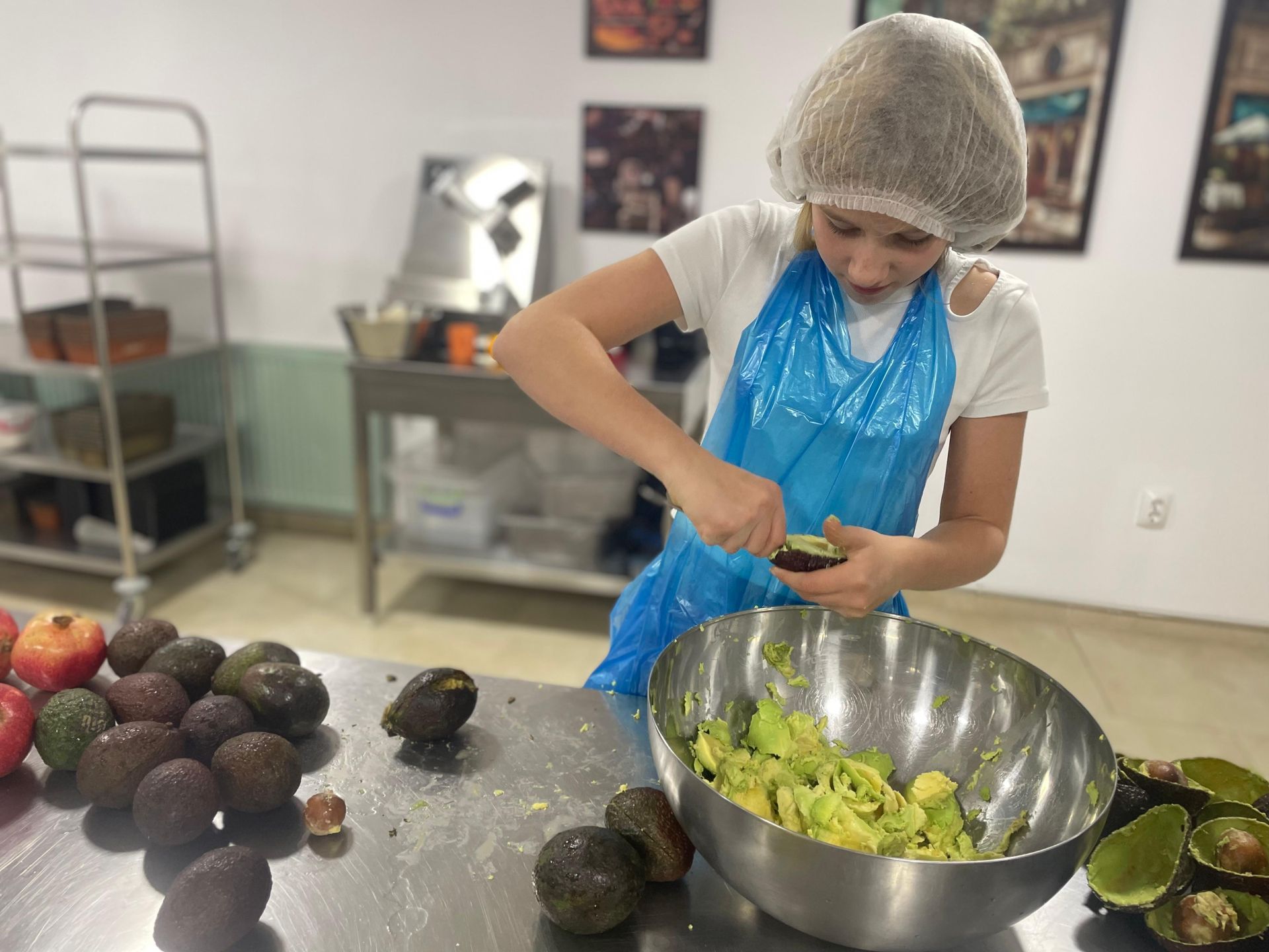 A woman is peeling an avocado in a kitchen.