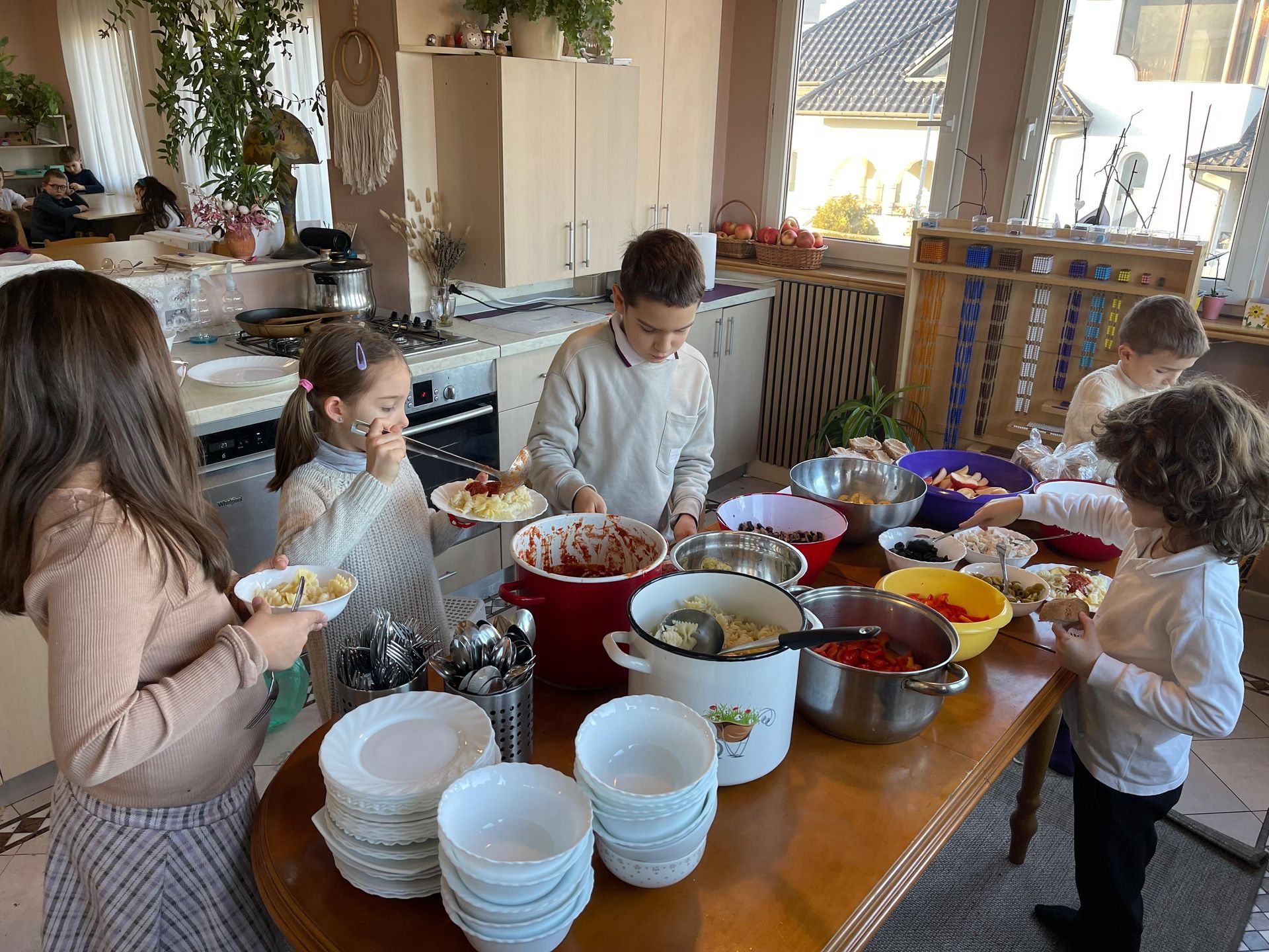 A group of children are standing around a table eating food.