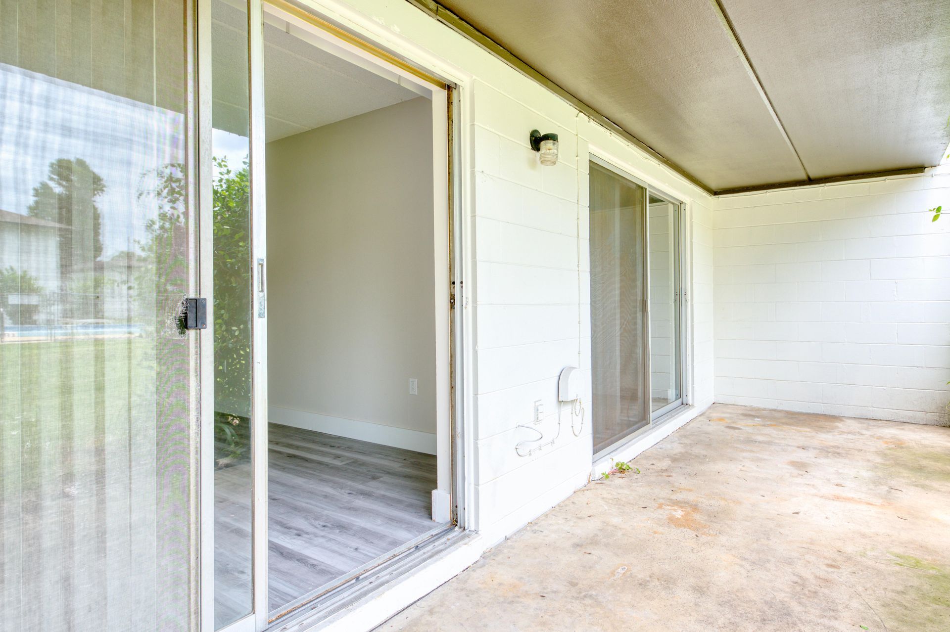A patio with sliding glass doors leading to a living room.