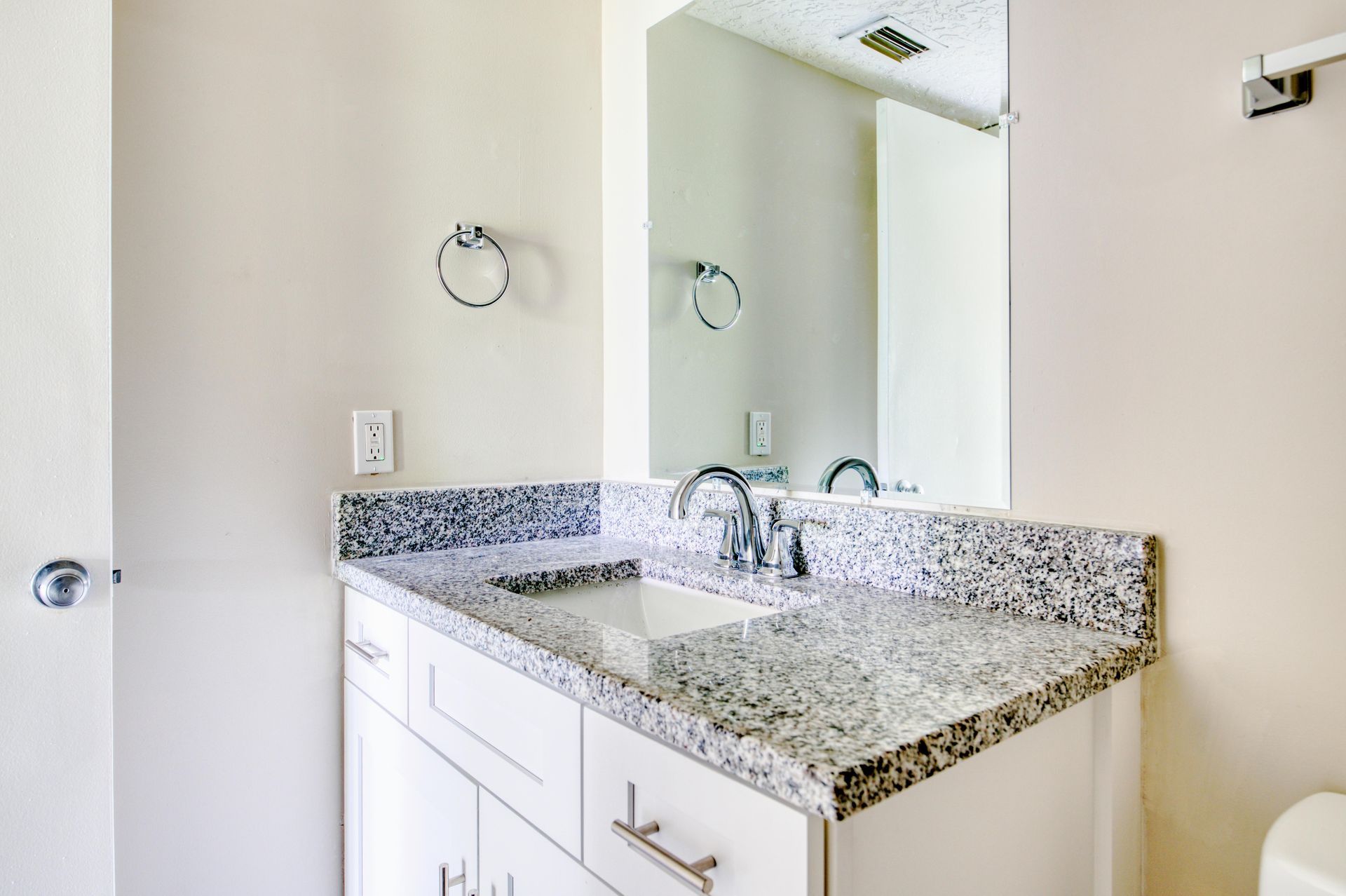 A bathroom with a sink , toilet and mirror.