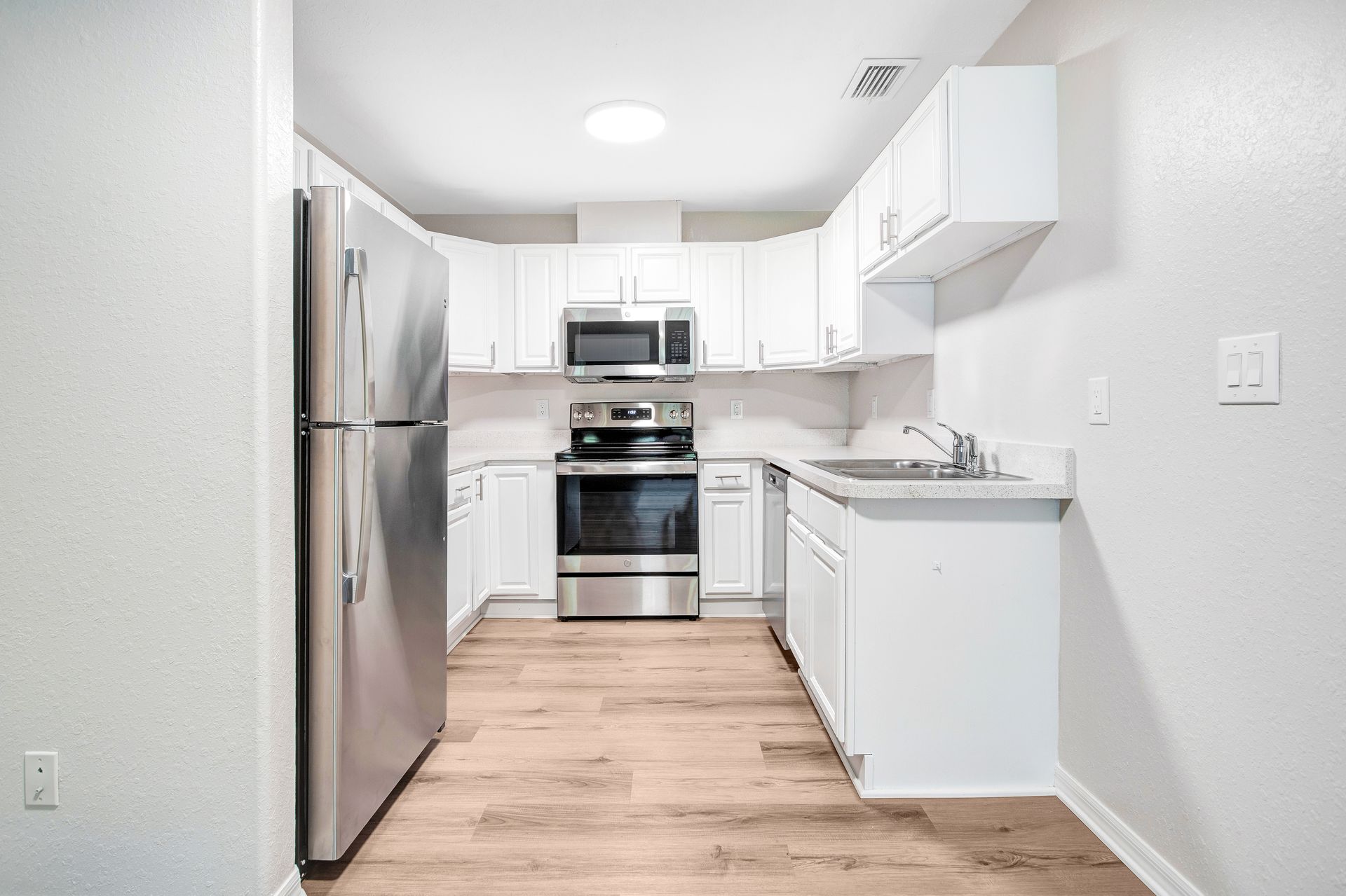 A kitchen with white cabinets and stainless steel appliances