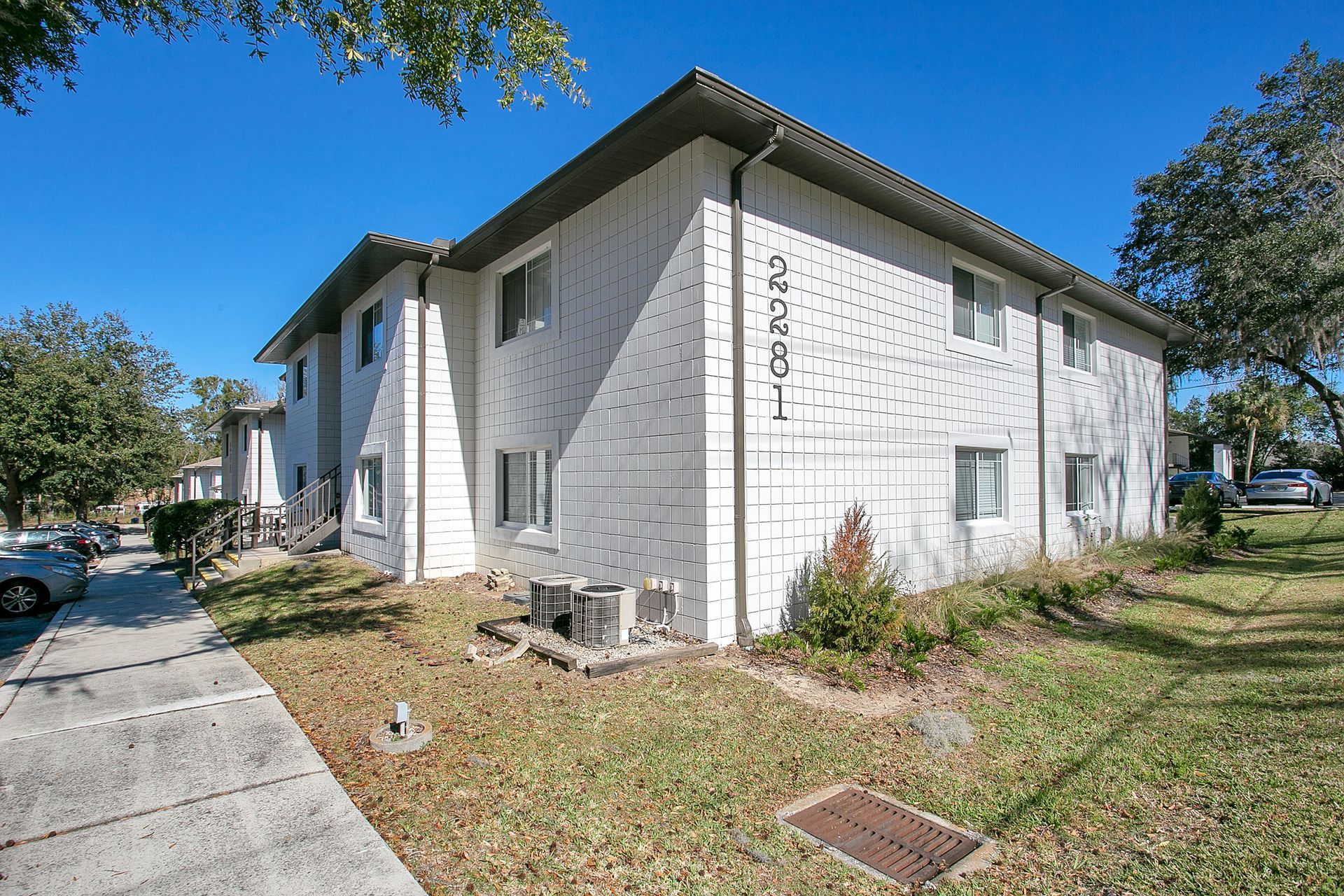 A white apartment building with landscaping