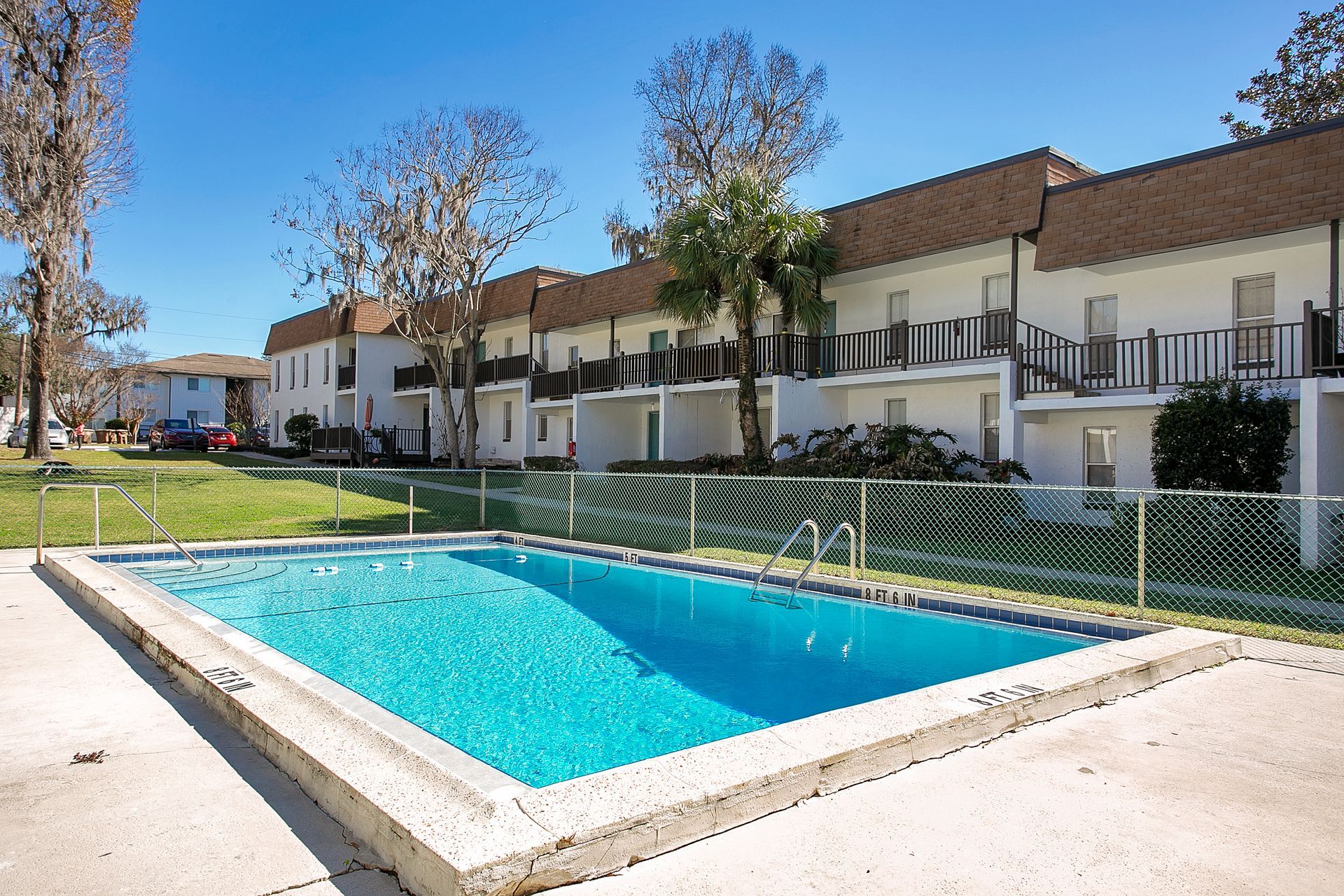 A large swimming pool in front of an apartment building. 