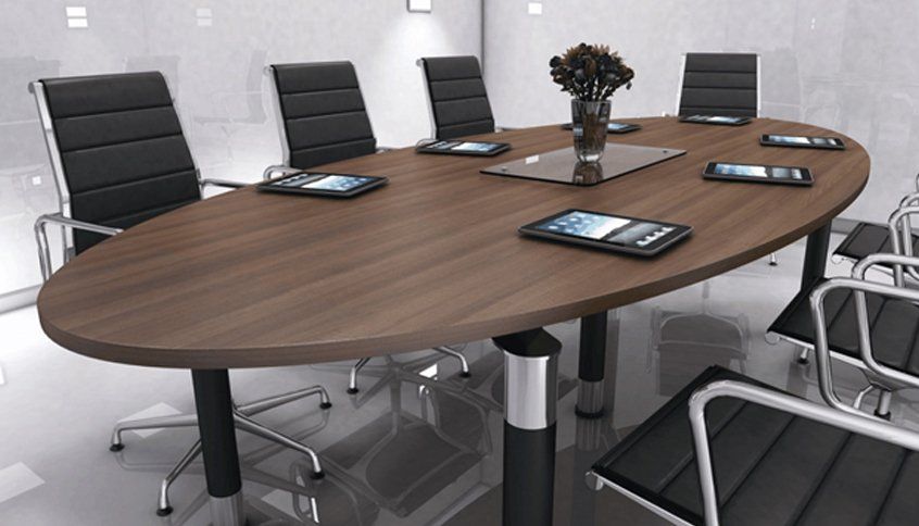 An oval table with 7 chairs and tablets