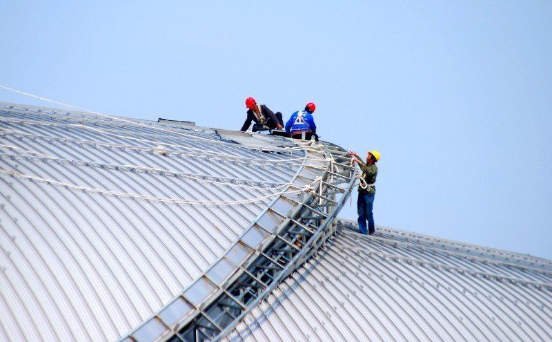 Three builders on a roof