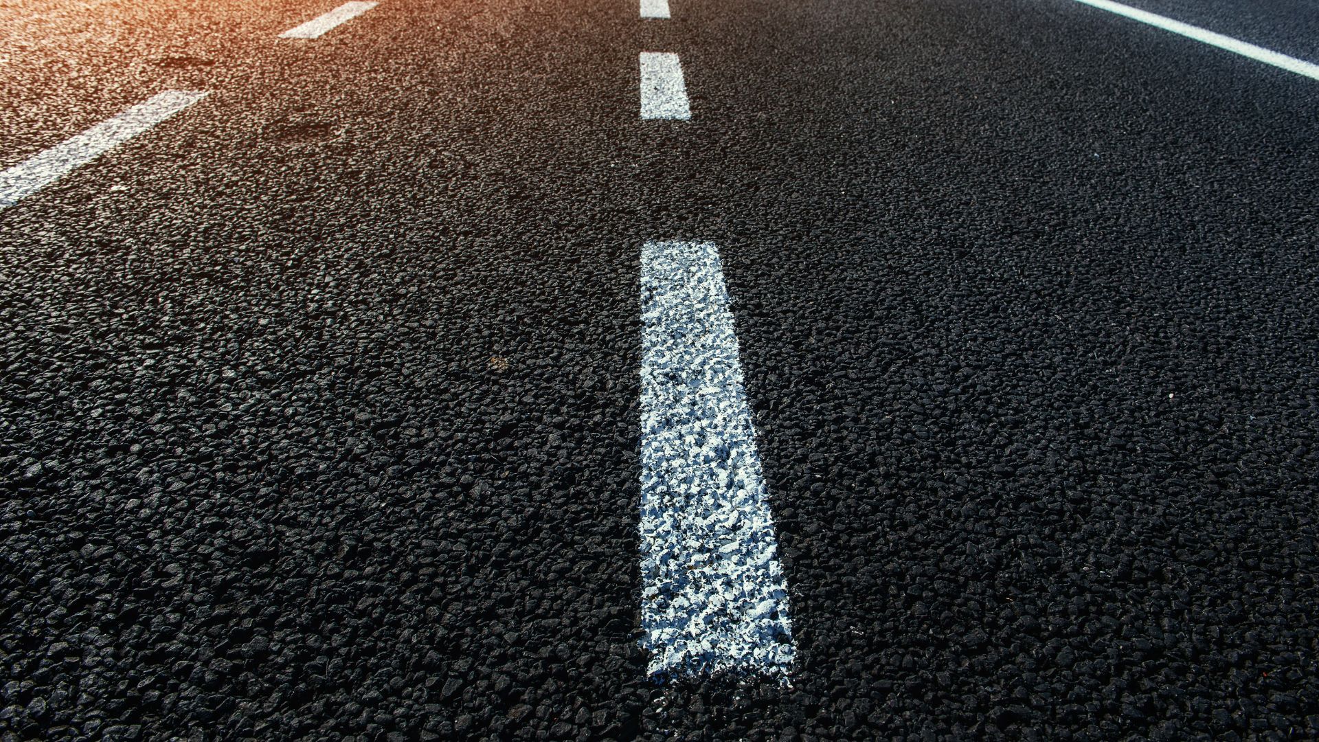 A close up of a road with a white line on it.