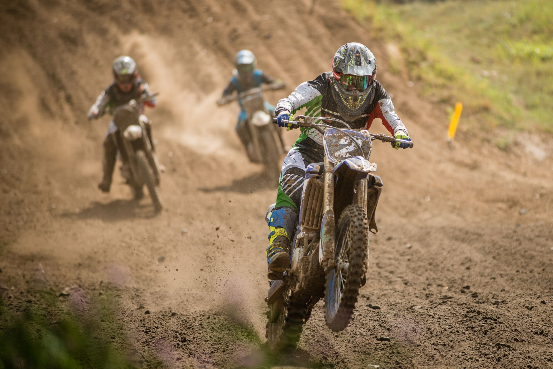 A group of people are riding dirt bikes on a dirt track.