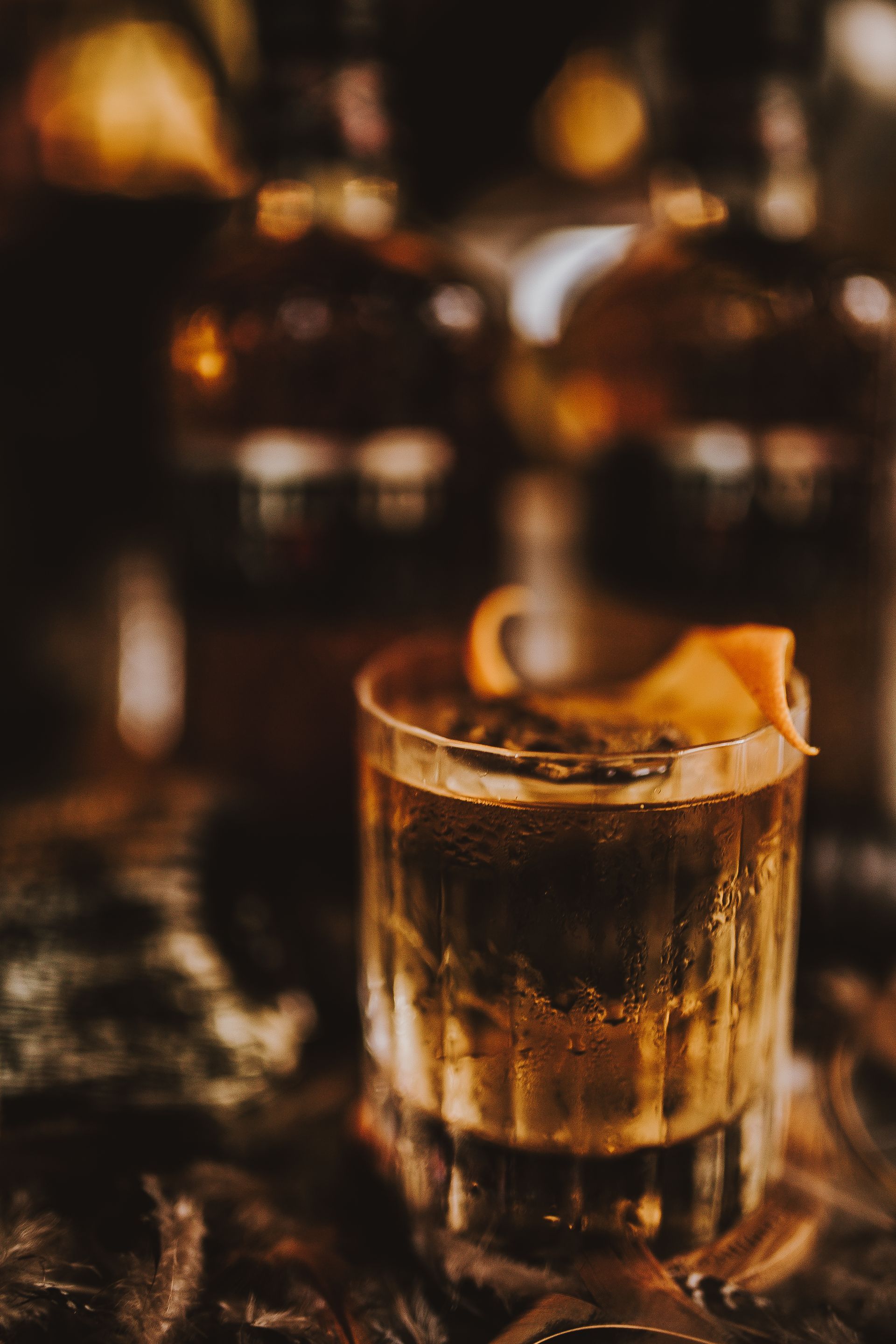 A close up of a glass of whiskey on a table.