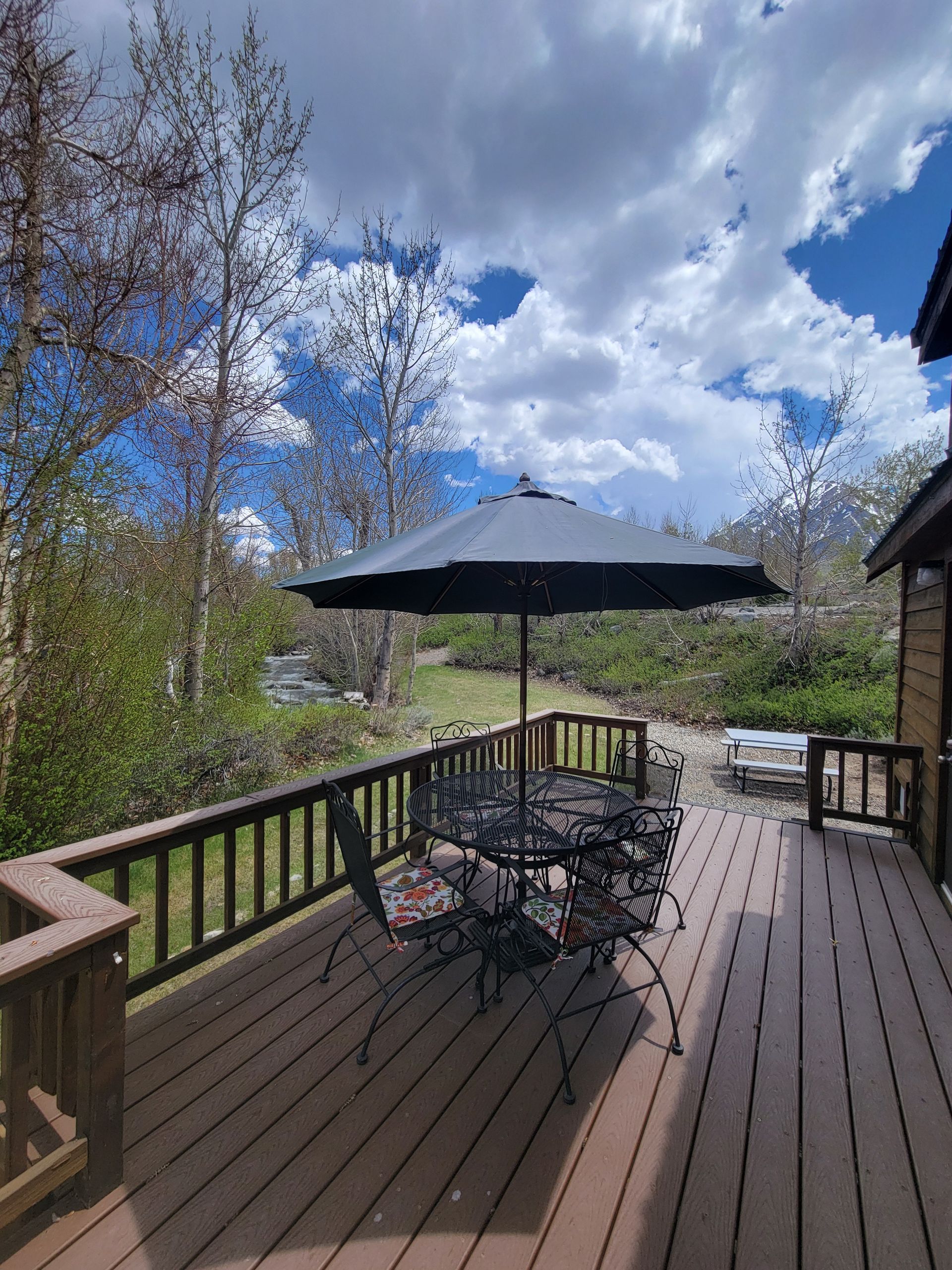 A deck with a table and chairs and an umbrella