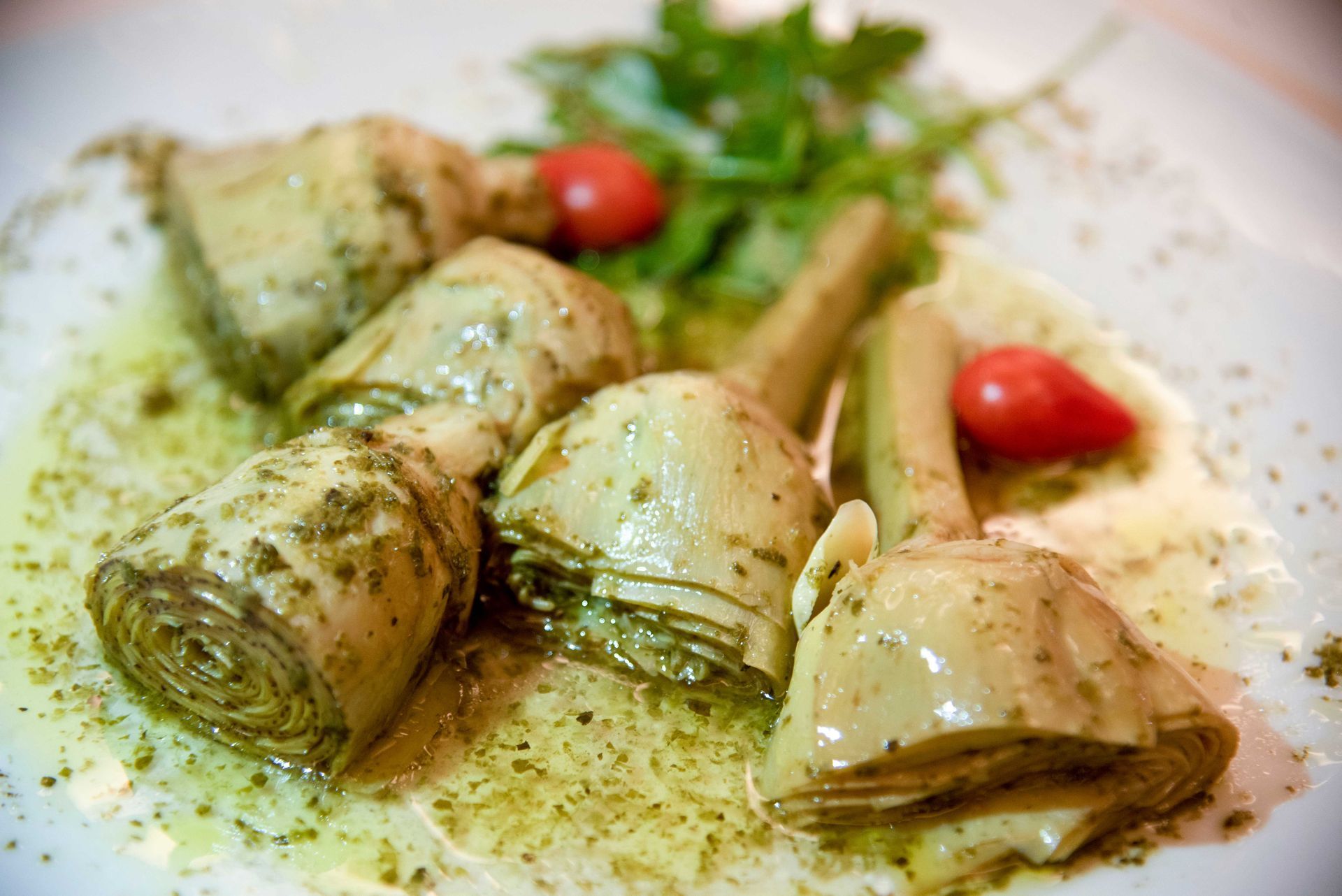 Cuori di carciofo in salsa verde con pomodorini e rucola.