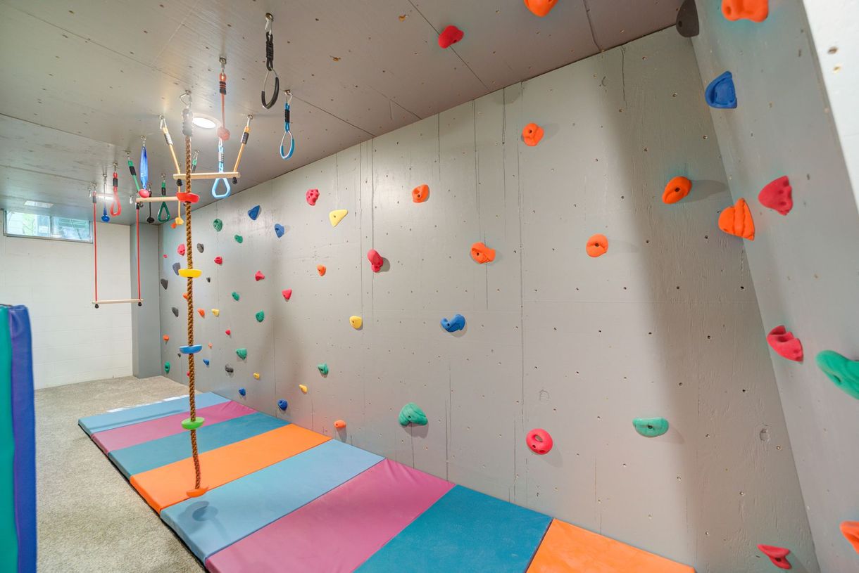 There is a climbing wall in the corner of the room.