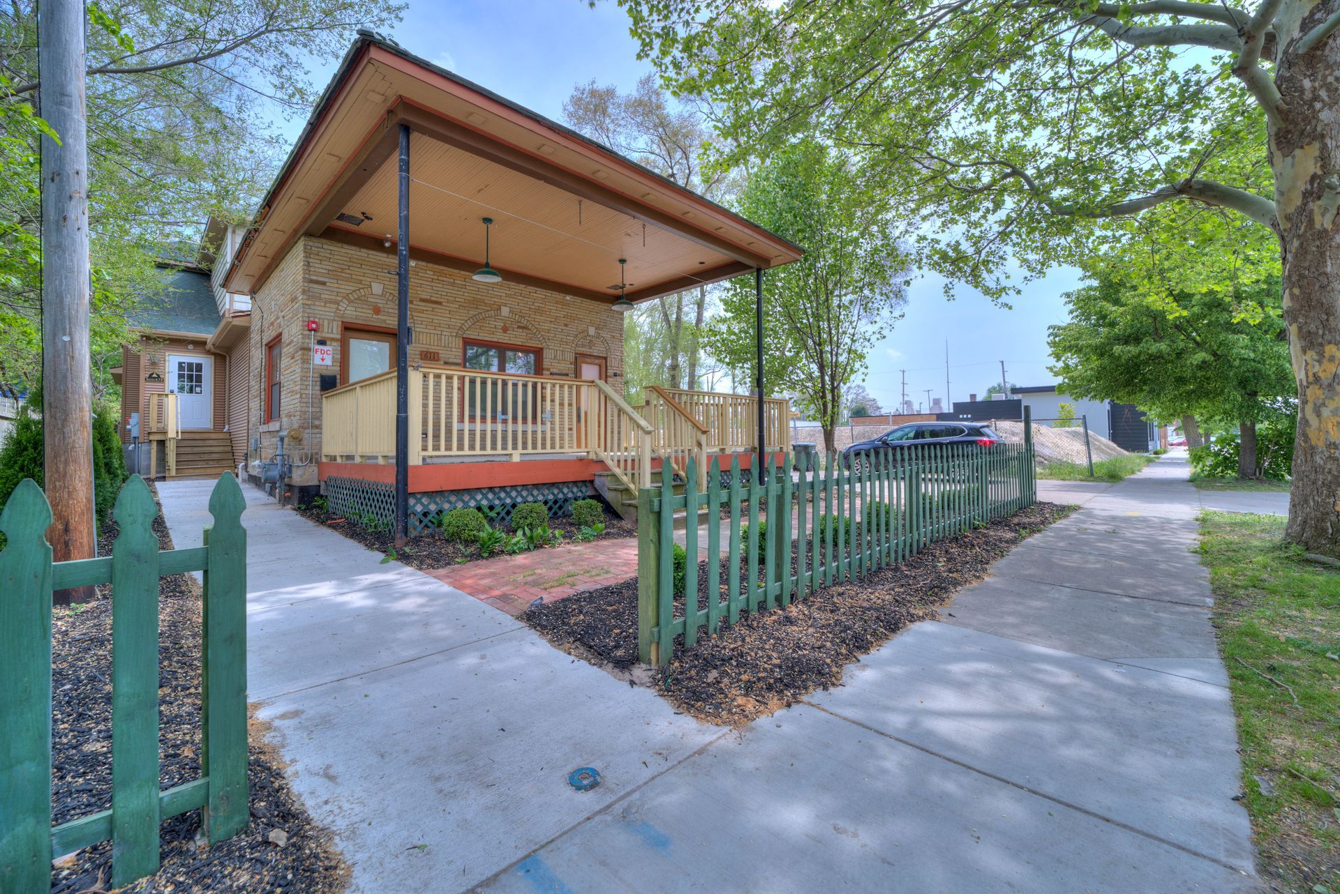 A house with a porch and a green picket fence