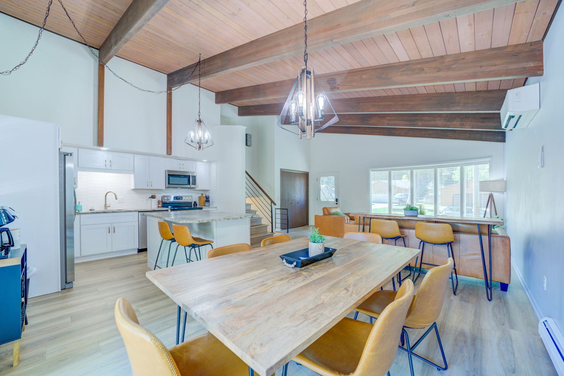 A dining room with a wooden table and yellow chairs in a house.