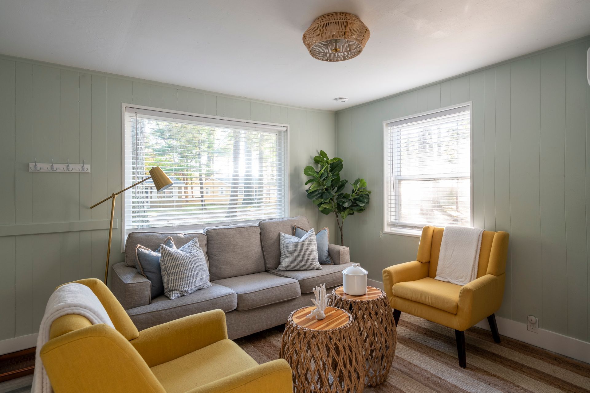 A living room with a couch , chairs , tables and a window.