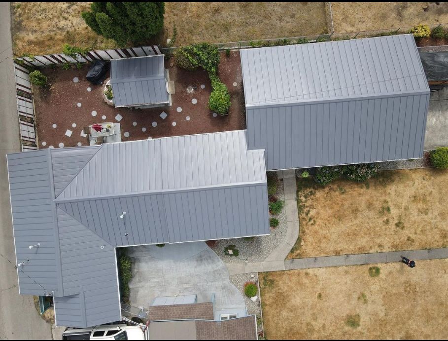 An aerial view of a house with a gray roof