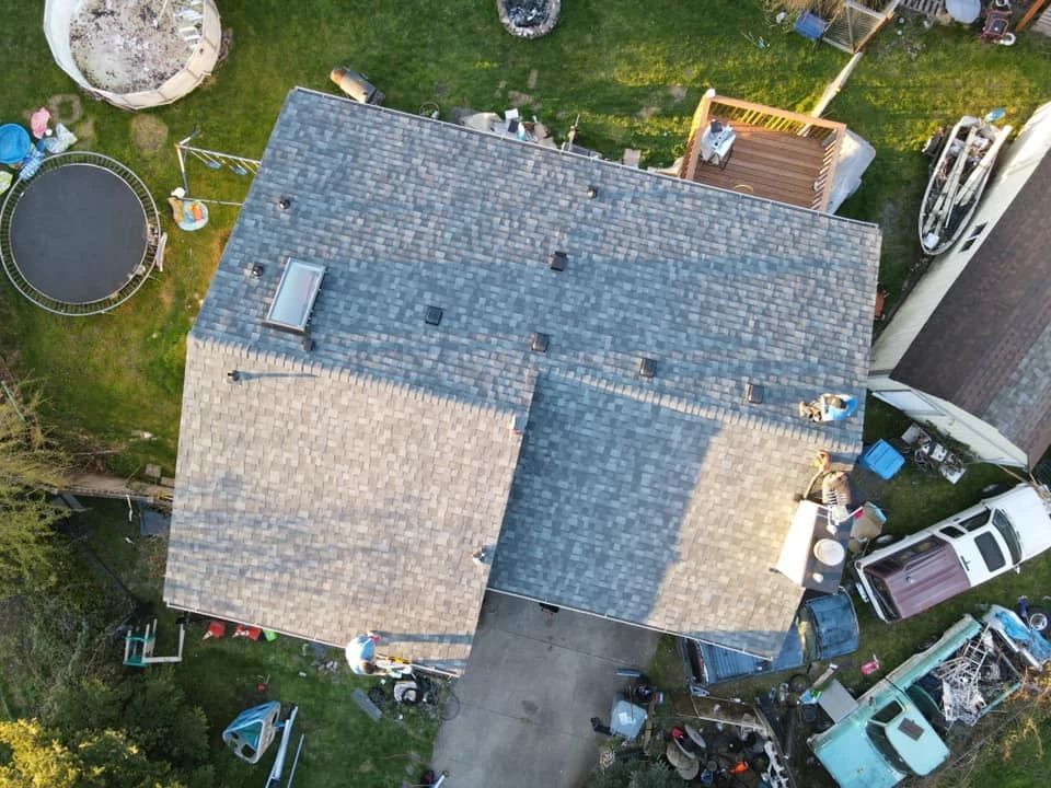An aerial view of a house with a trampoline in the backyard.