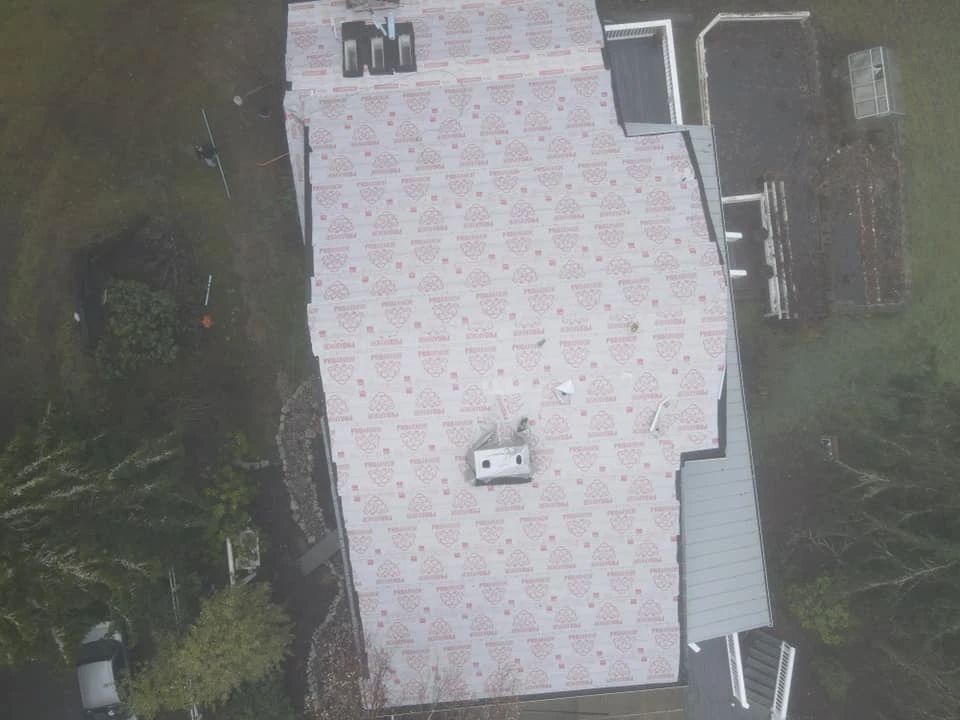An aerial view of a house with a roof that is covered in shingles.
