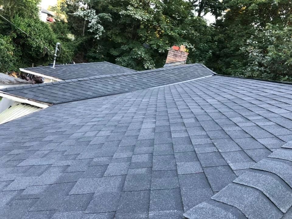 A roof with a lot of tiles on it and trees in the background.