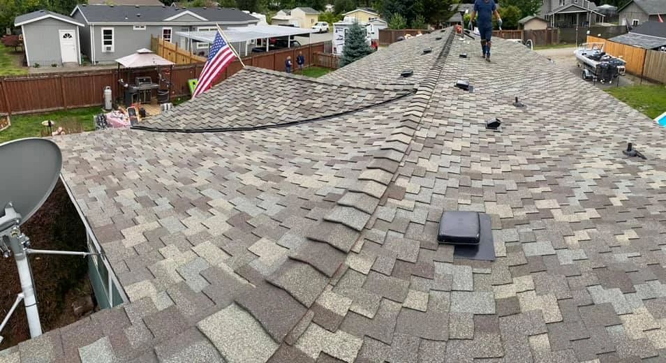 A man is standing on the roof of a house.