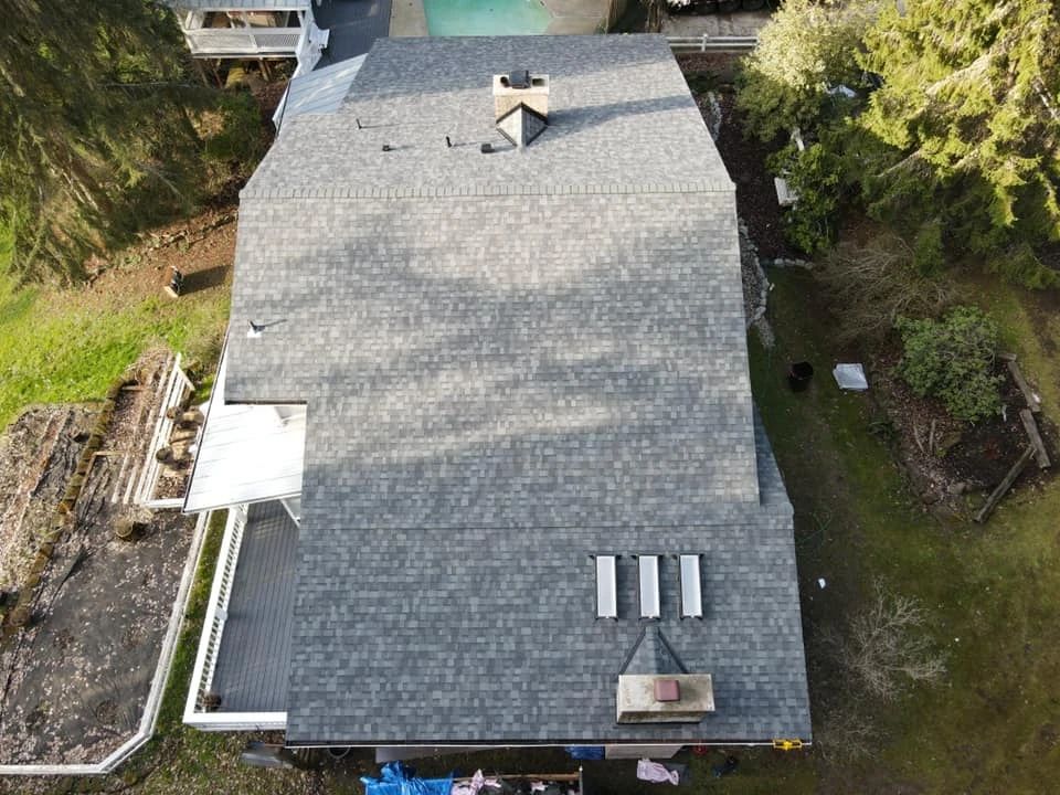 An aerial view of a large house with a roof and a pool.
