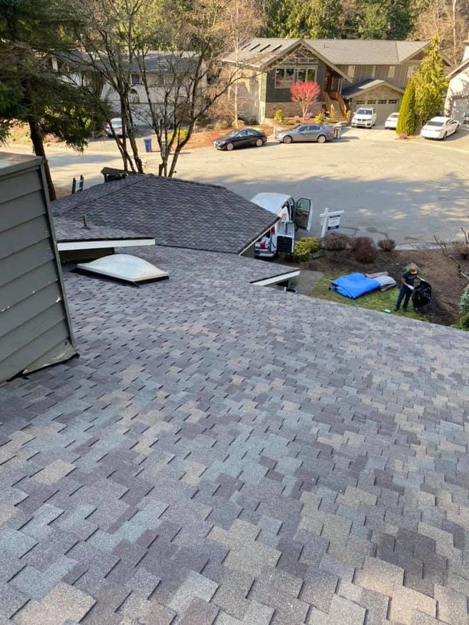 A roof is being installed on a house in a residential area.