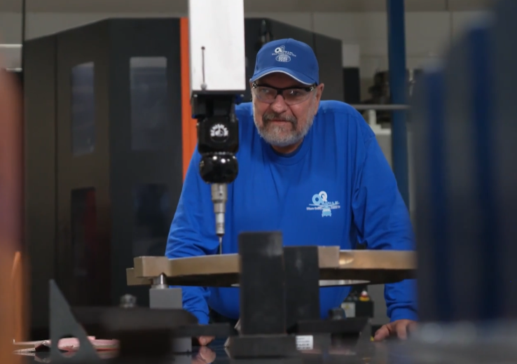 A man in a blue shirt is working on a machine