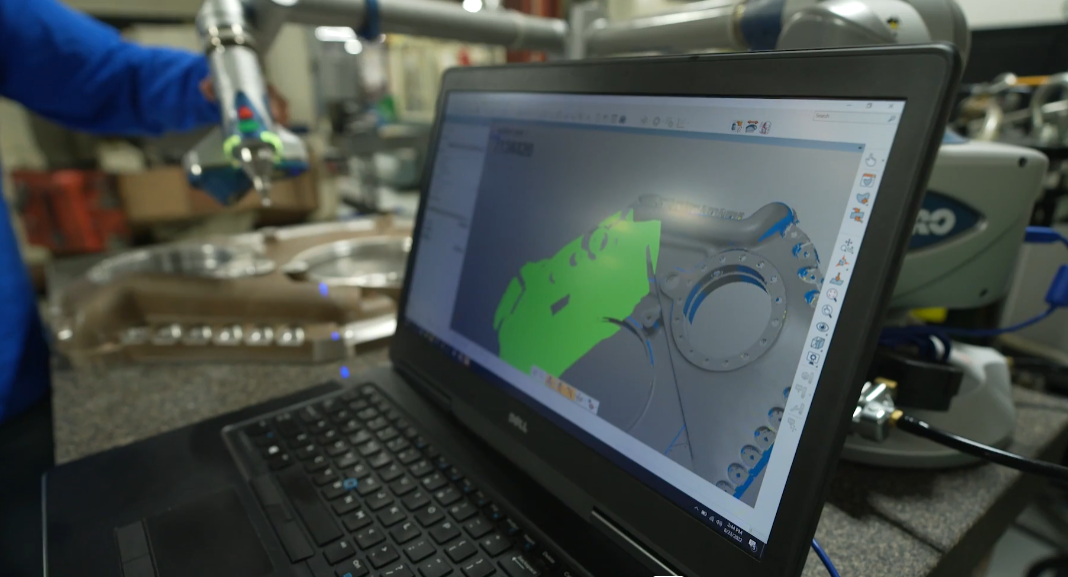 A laptop computer is sitting on a table in a factory.