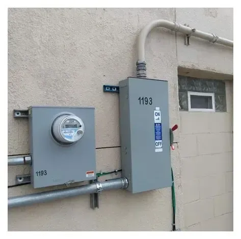 A meter and a box on the side of a building.