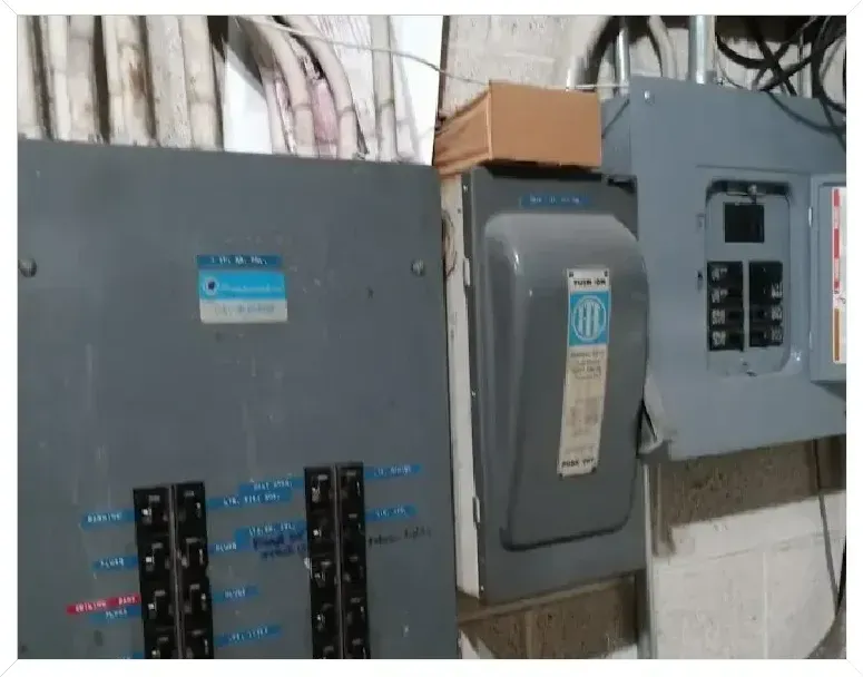 Two electrical panels are sitting next to each other on a wall.