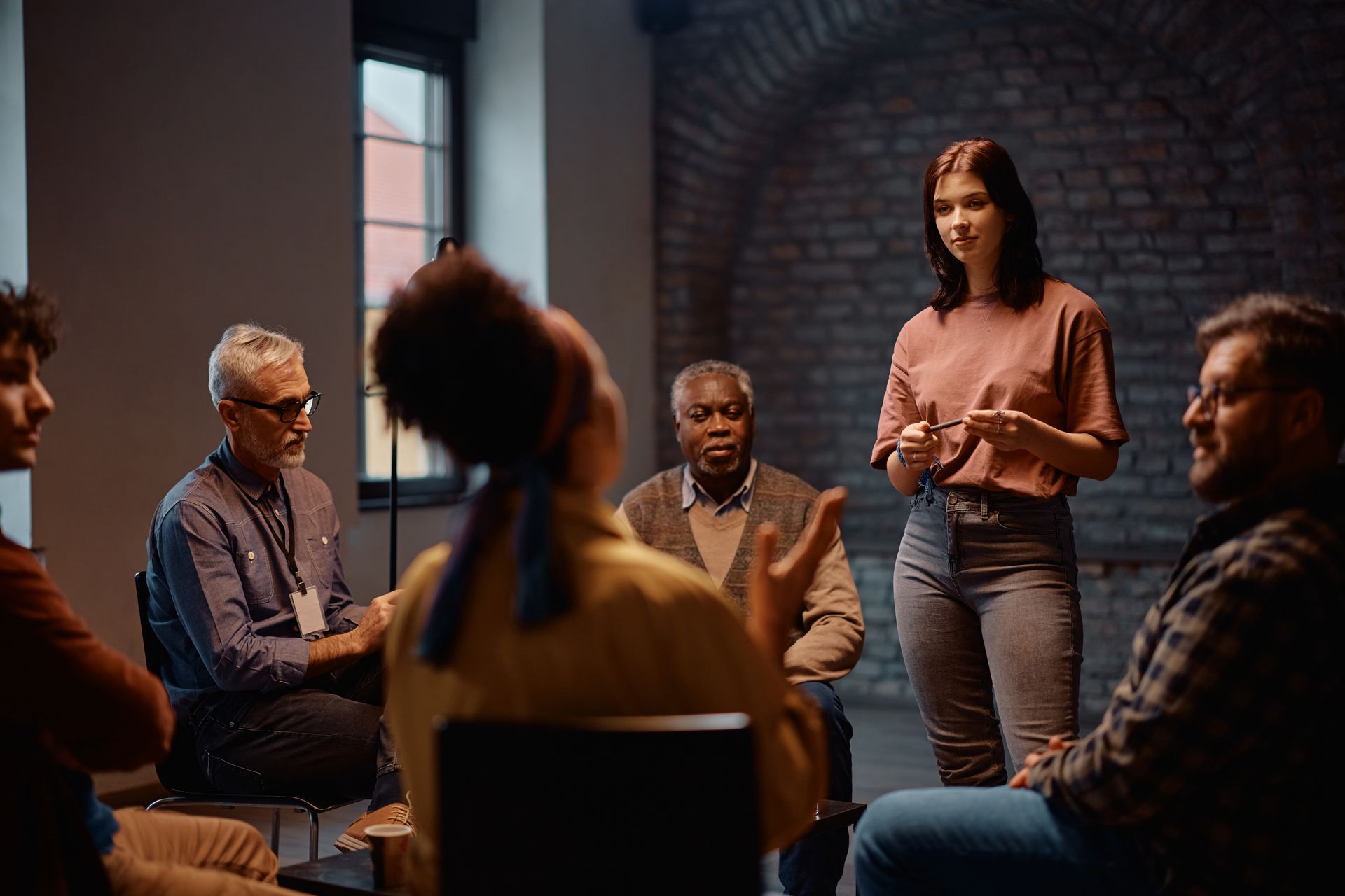 Young woman sharing during a support group at a community center.