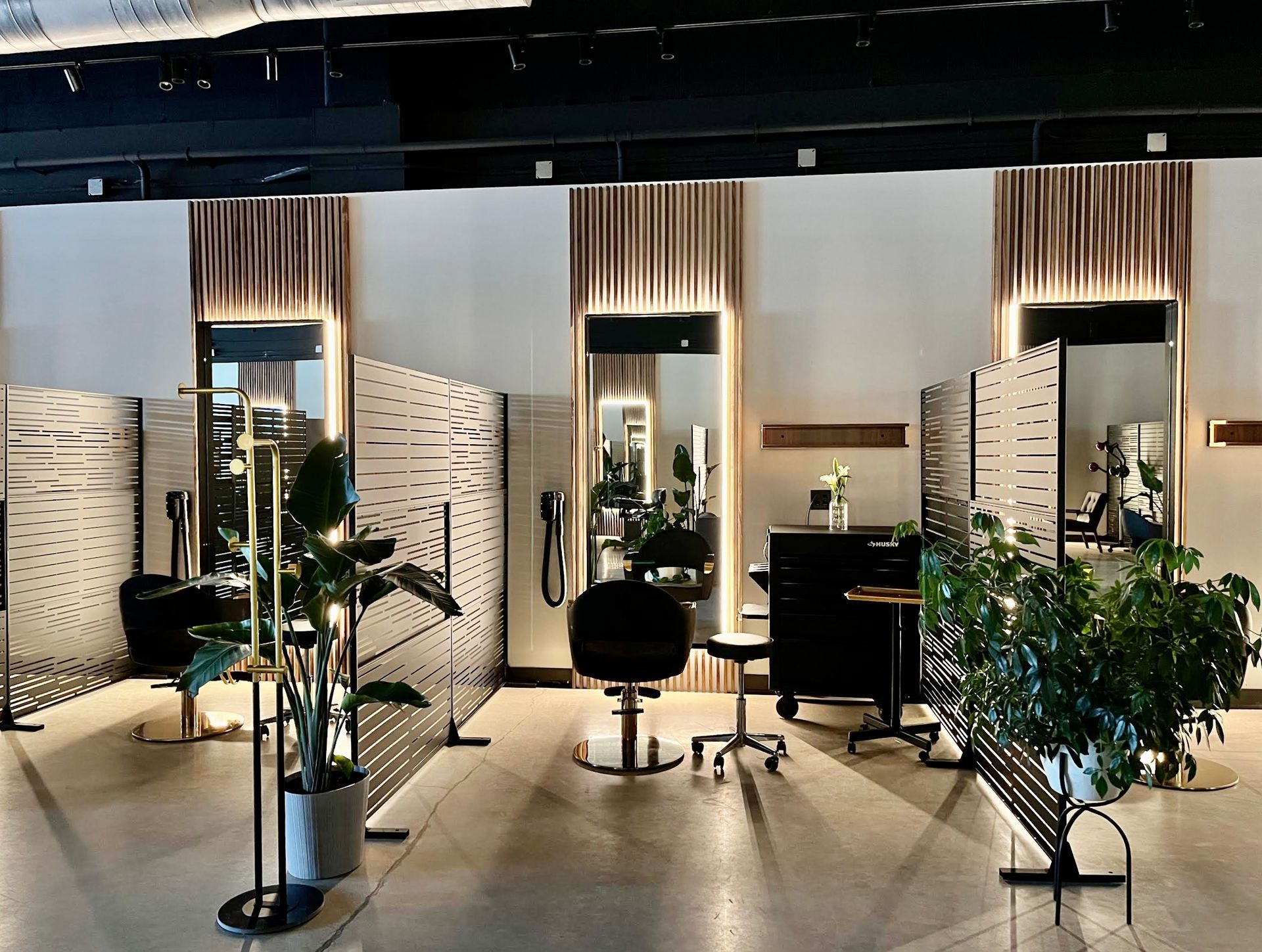 Hair salon interior with mirrors, styling stations, and decorative screens.