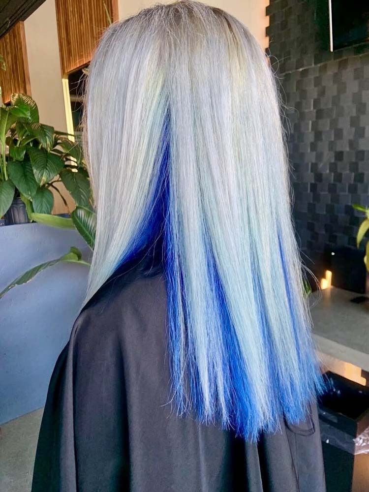 Person with long, straight silver hair, blue highlights visible underneath.