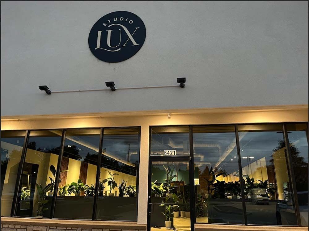 Studio LUX storefront with large windows and a round sign.