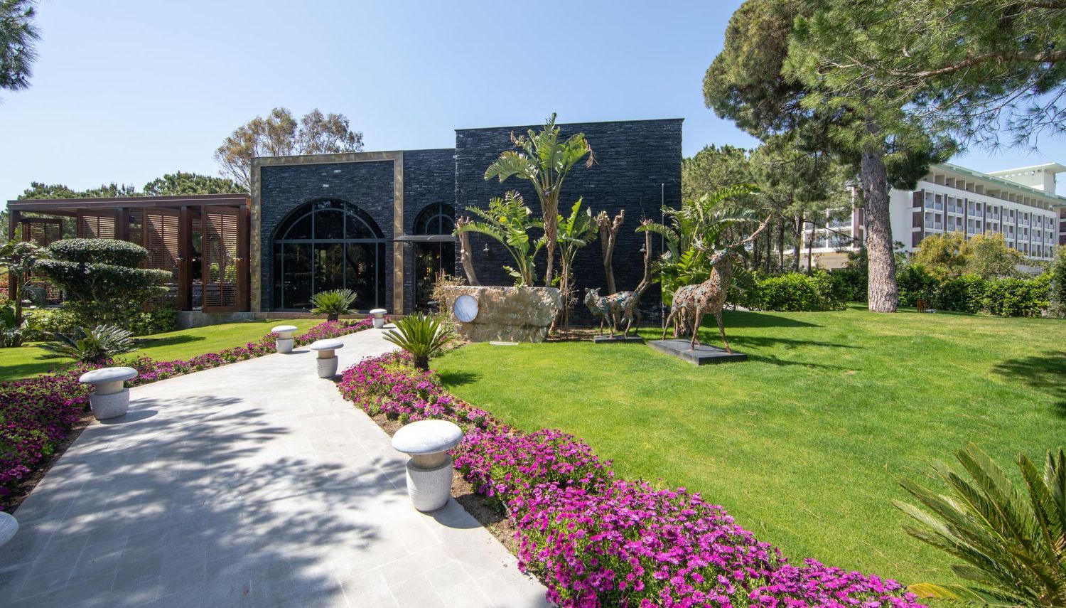 A large building with a lot of flowers in front of it.