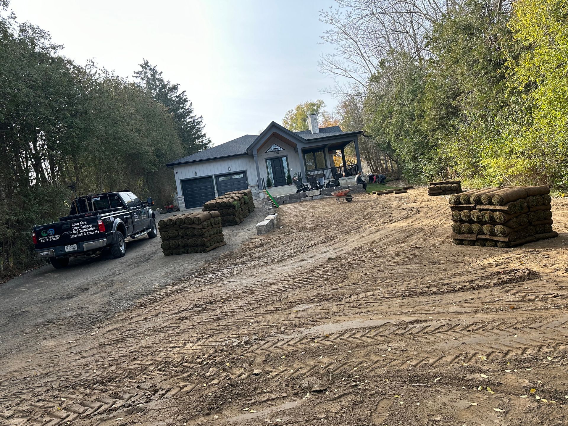 a truck is parked on the side of a dirt road in front of a house .