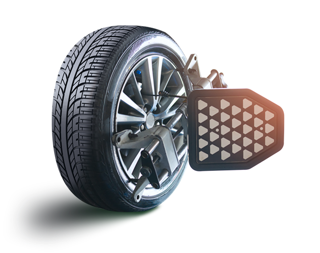 Car wheel with alignment tool attached, white background.