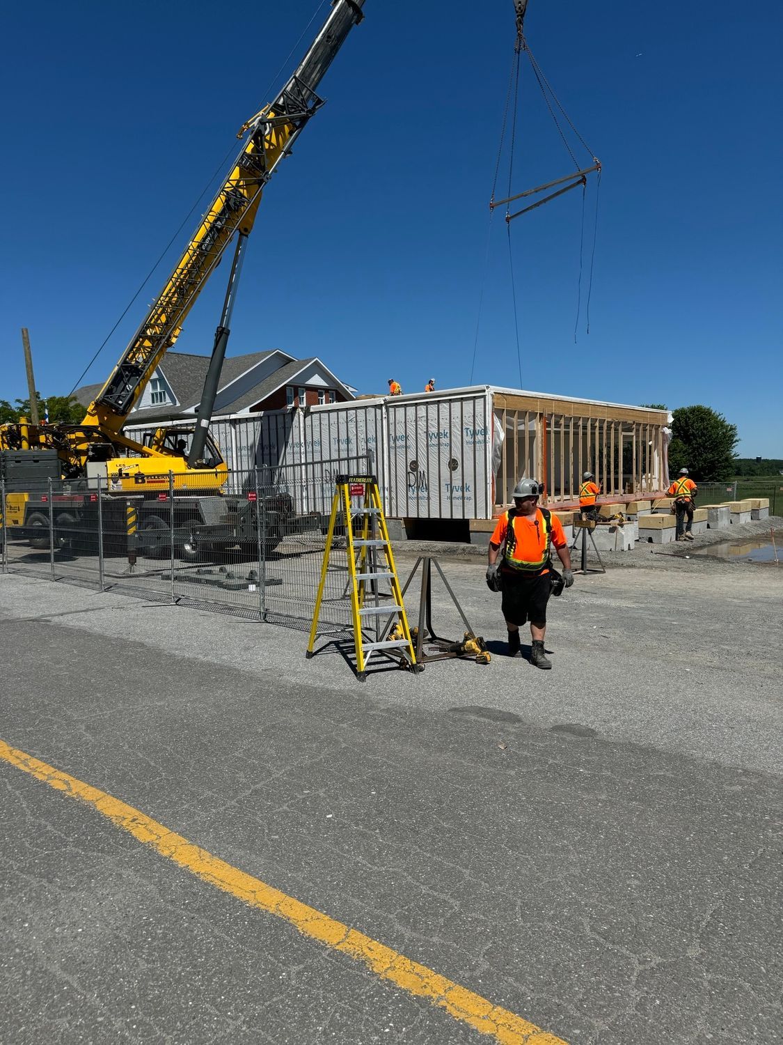 A construction site with a yellow crane and a ladder