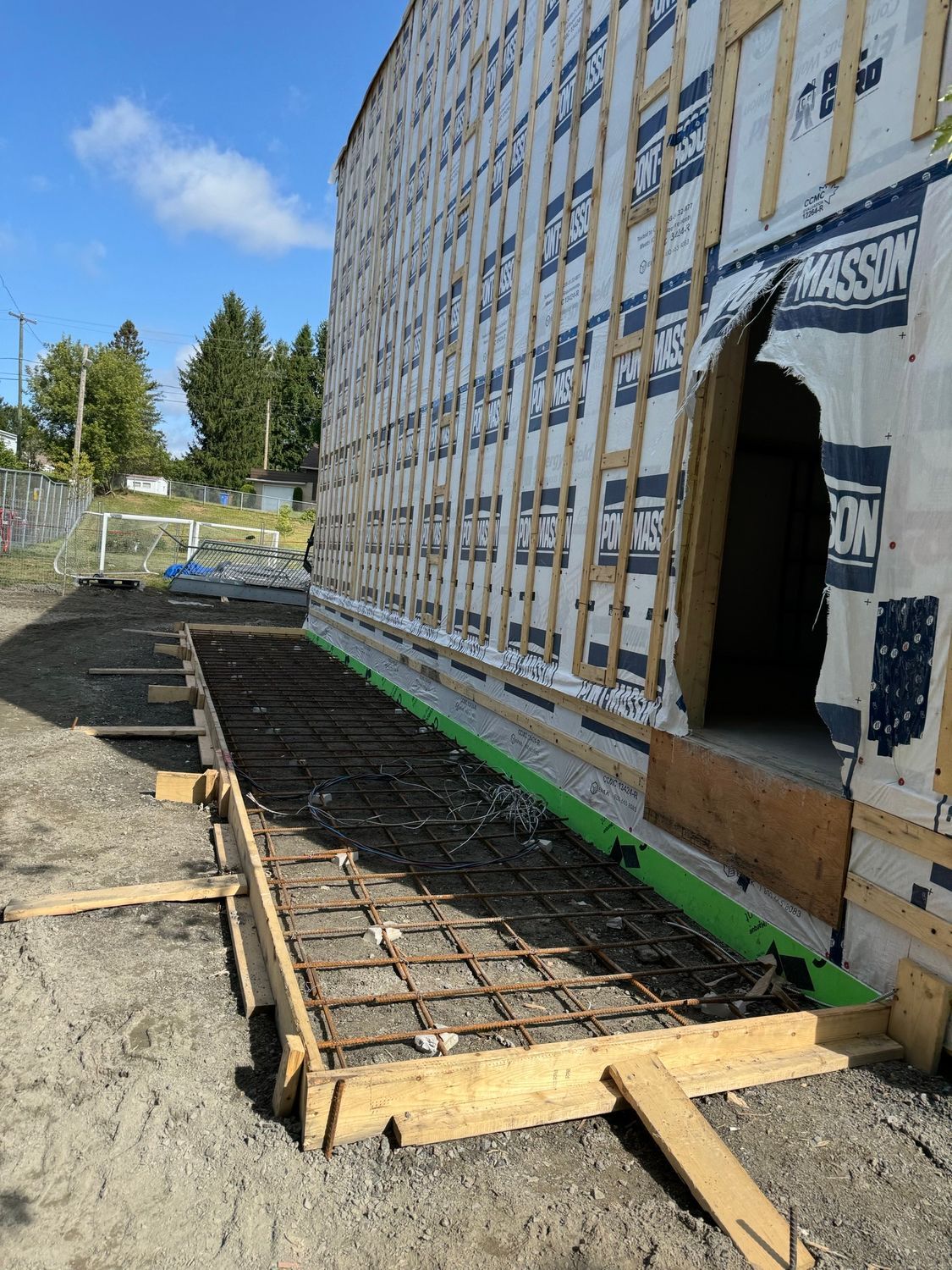 A large building is being built and there is a concrete slab in front of it