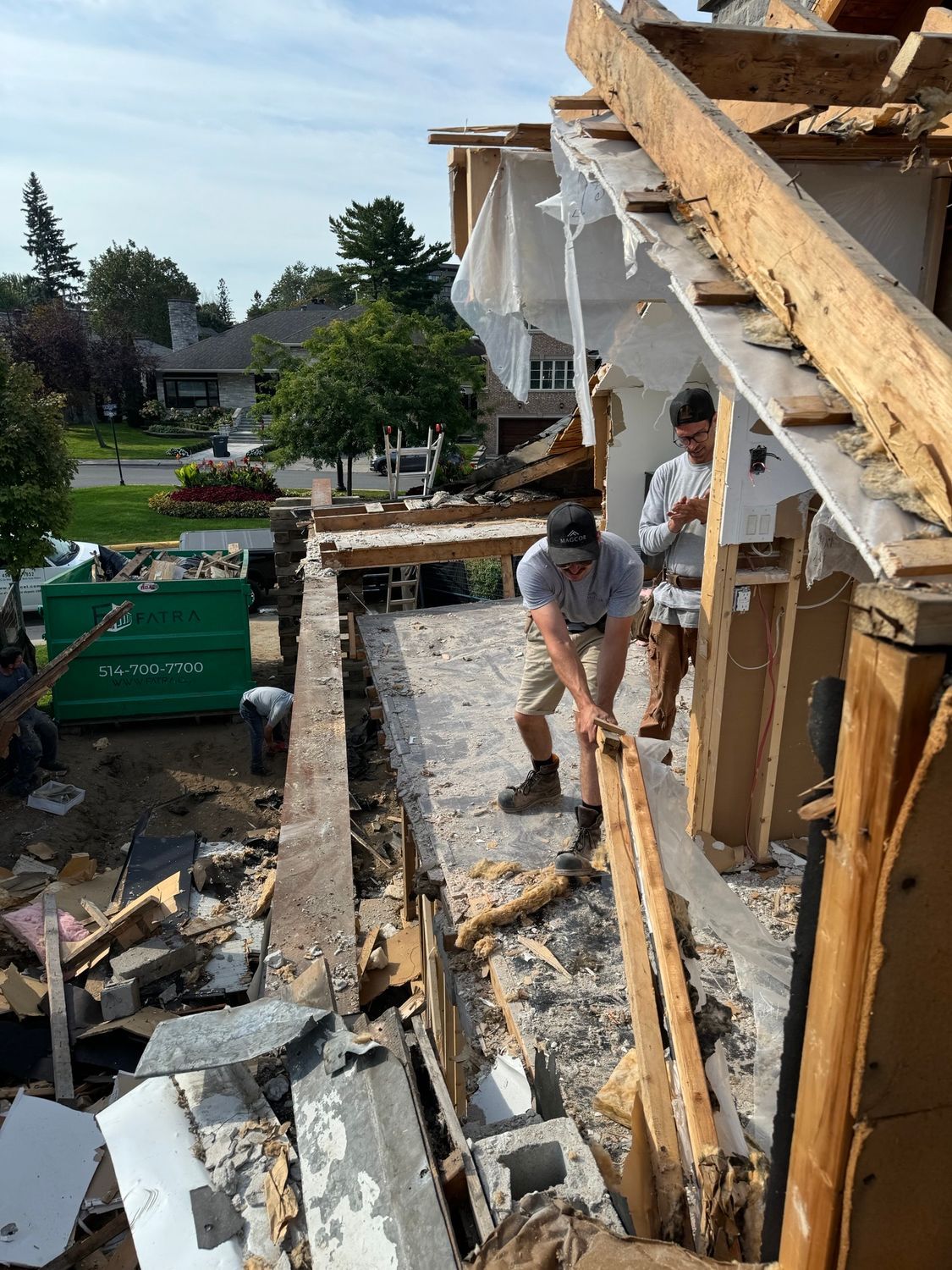 A man is standing on the roof of a building that is being demolished