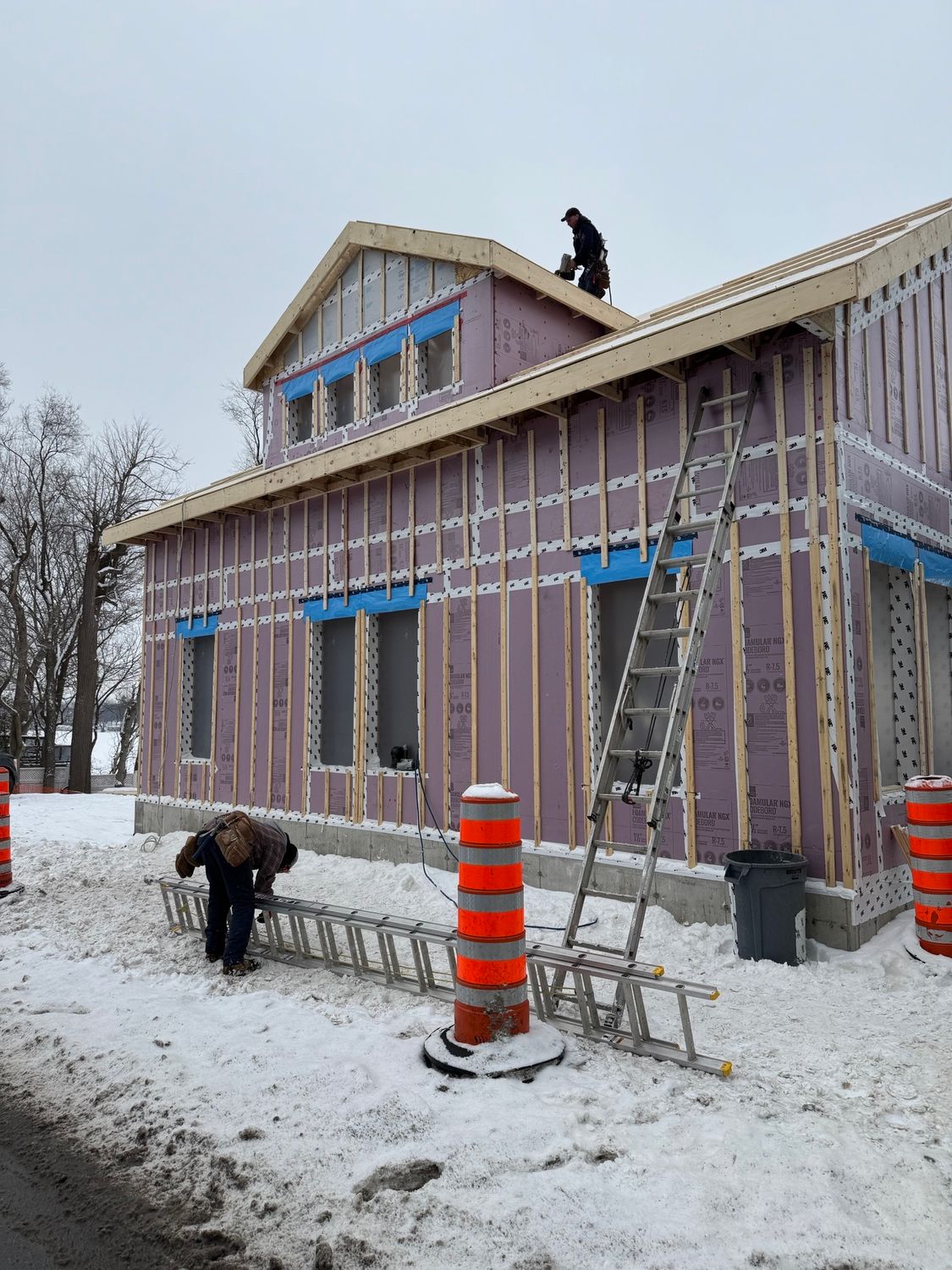 A man is working on the roof of a building under construction