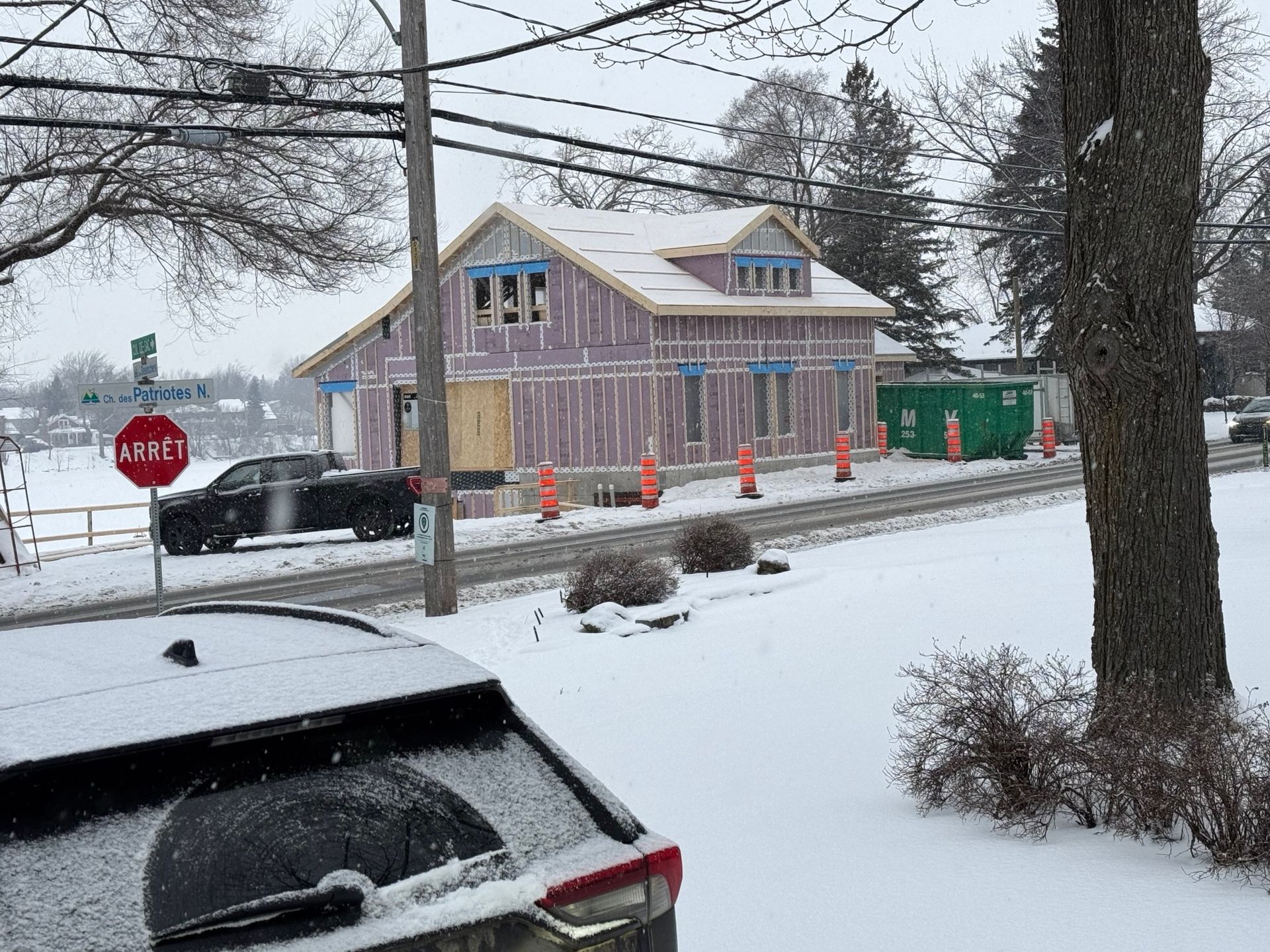 A stop sign is in front of a house under construction