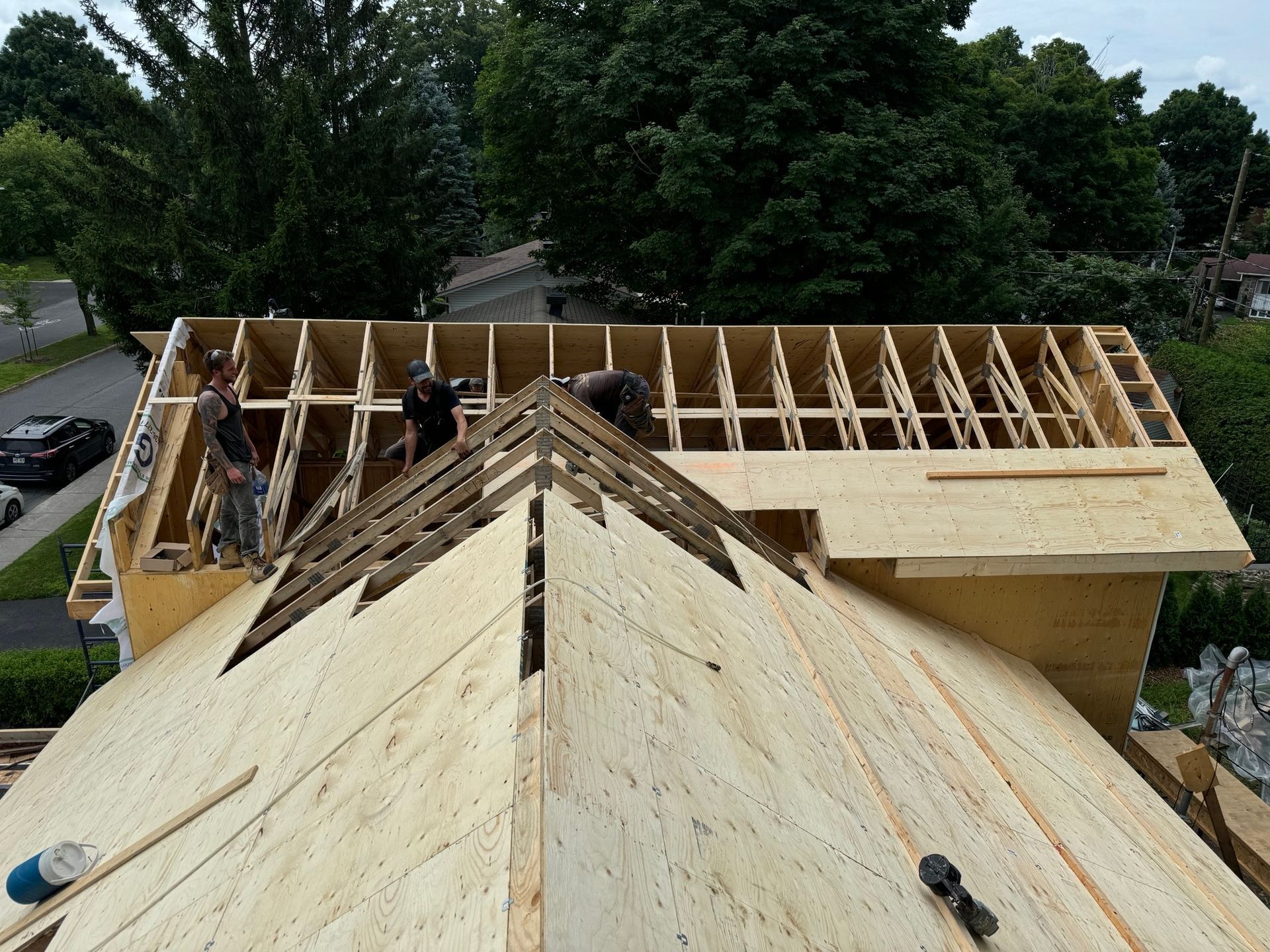 A group of people are working on a wooden roof
