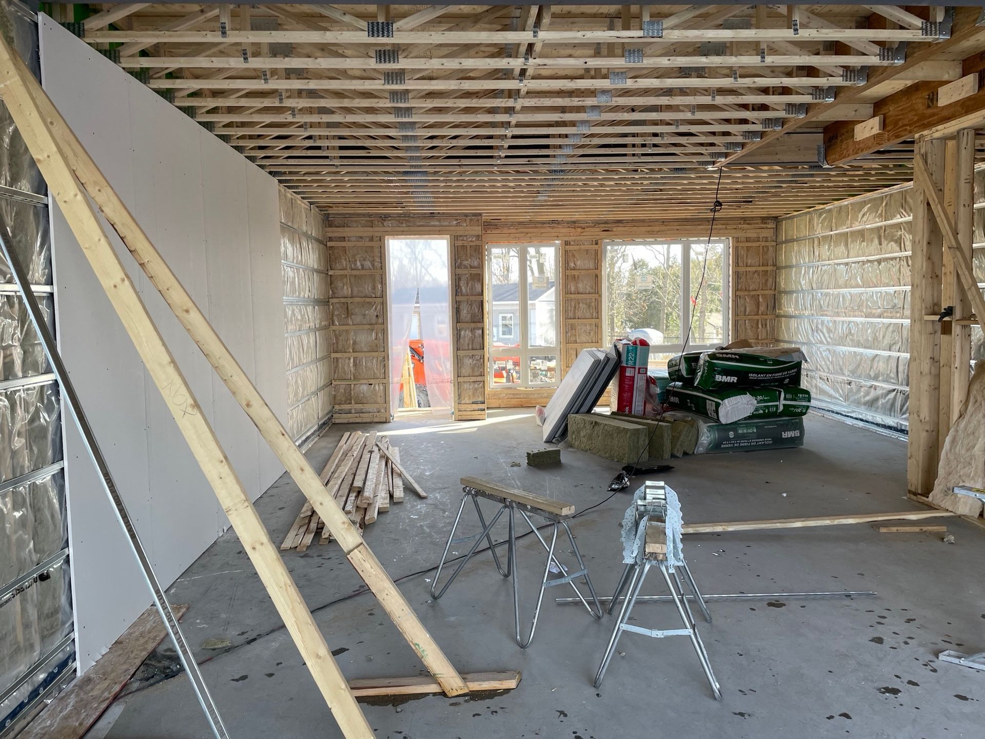 A room that is being built with a lot of wood and a ladder.